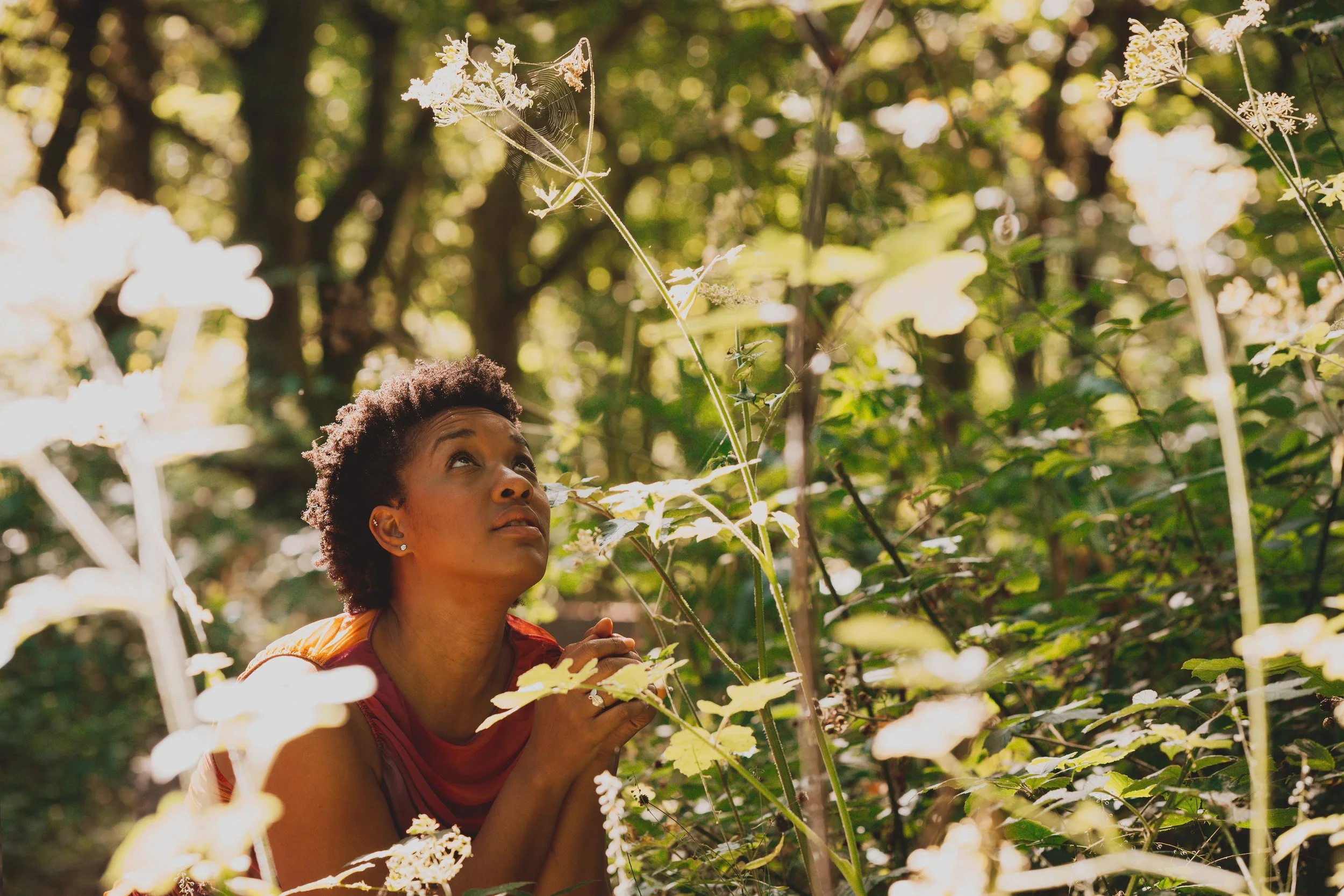 She is close, and crouching low in the midst of tall grass. Her hands are held like a prayer and her eyes search the sky.