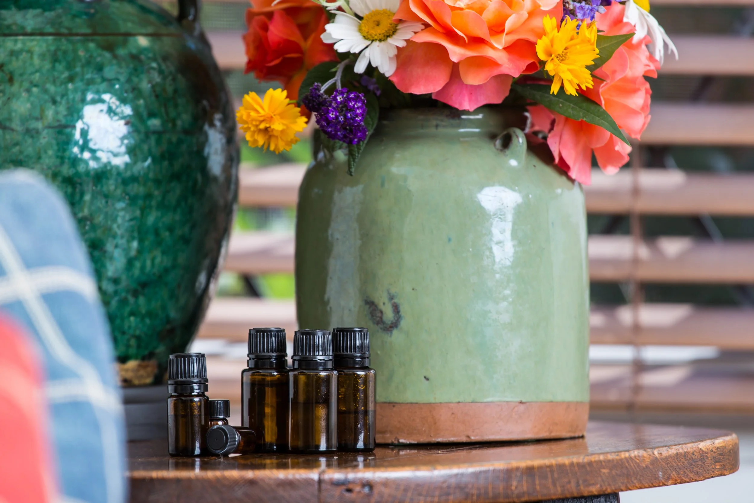 oil bottles by a vase of flowers