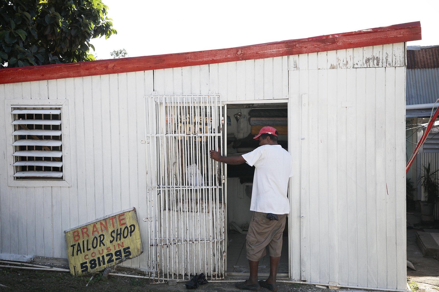 A man is framed by the doorway of a damaged tailor shop in the St Maartin, Virgin Islands on Dec. 19, 2019.