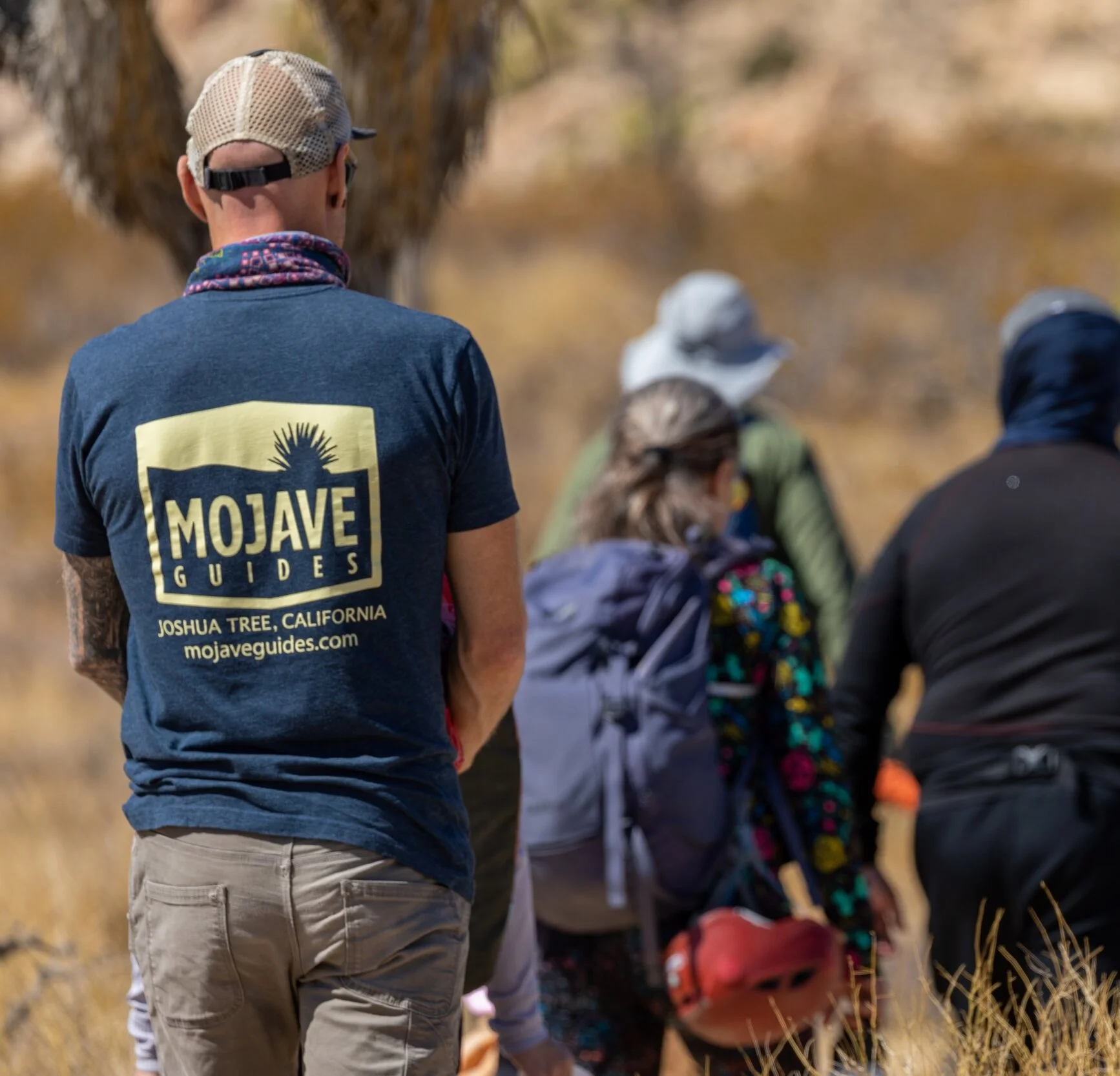 group of people with backpacks and a person wearing a Mojave Guides shirt