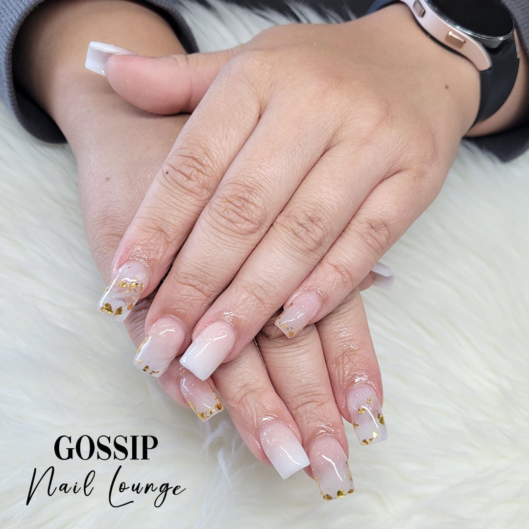 Enhance the elegance of your nails with the stunning white marble set featuring gold flakes. You'll love the way it looks and feels! #nails #gold #marblenails #gossipnaillounge #leessummit