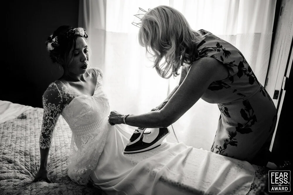 Mariée se faisant repasser sur elle sa robe par sa maman pendant les préparatifs de son mariage