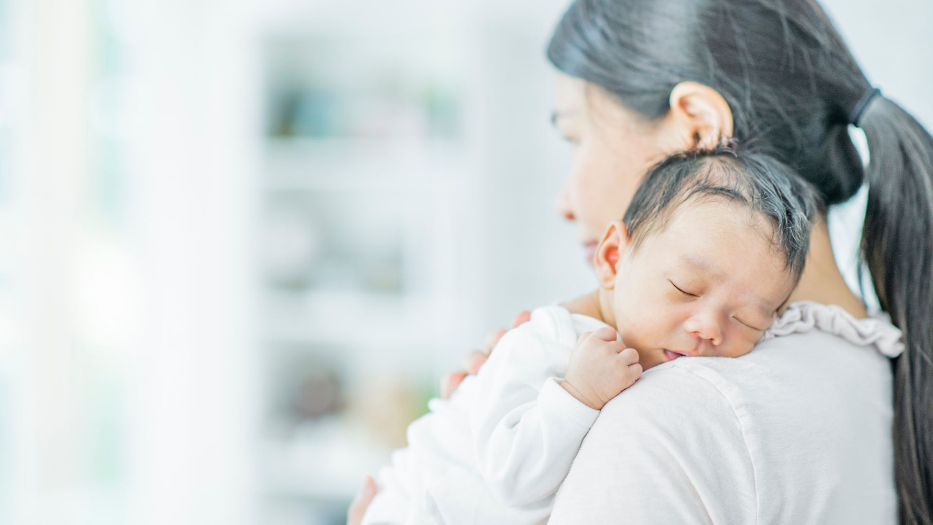 mom holding sleeping baby