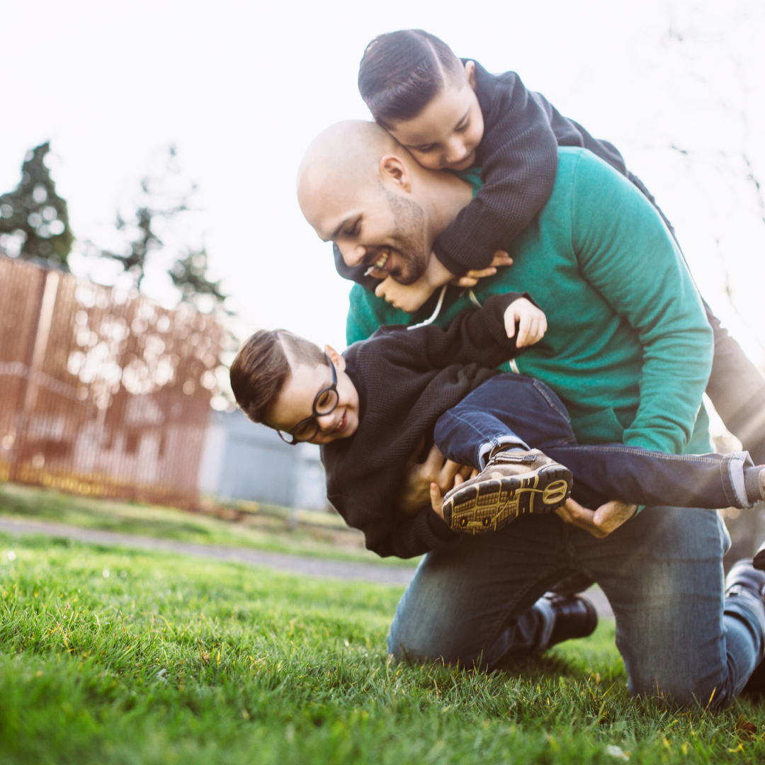adult giving two kids a piggy back ride
