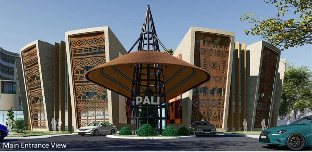 Main entrance view of a modern building with tribal designs on large panels, a central structure with a conical roof and the word 'PALI' displayed, and cars parked in front.