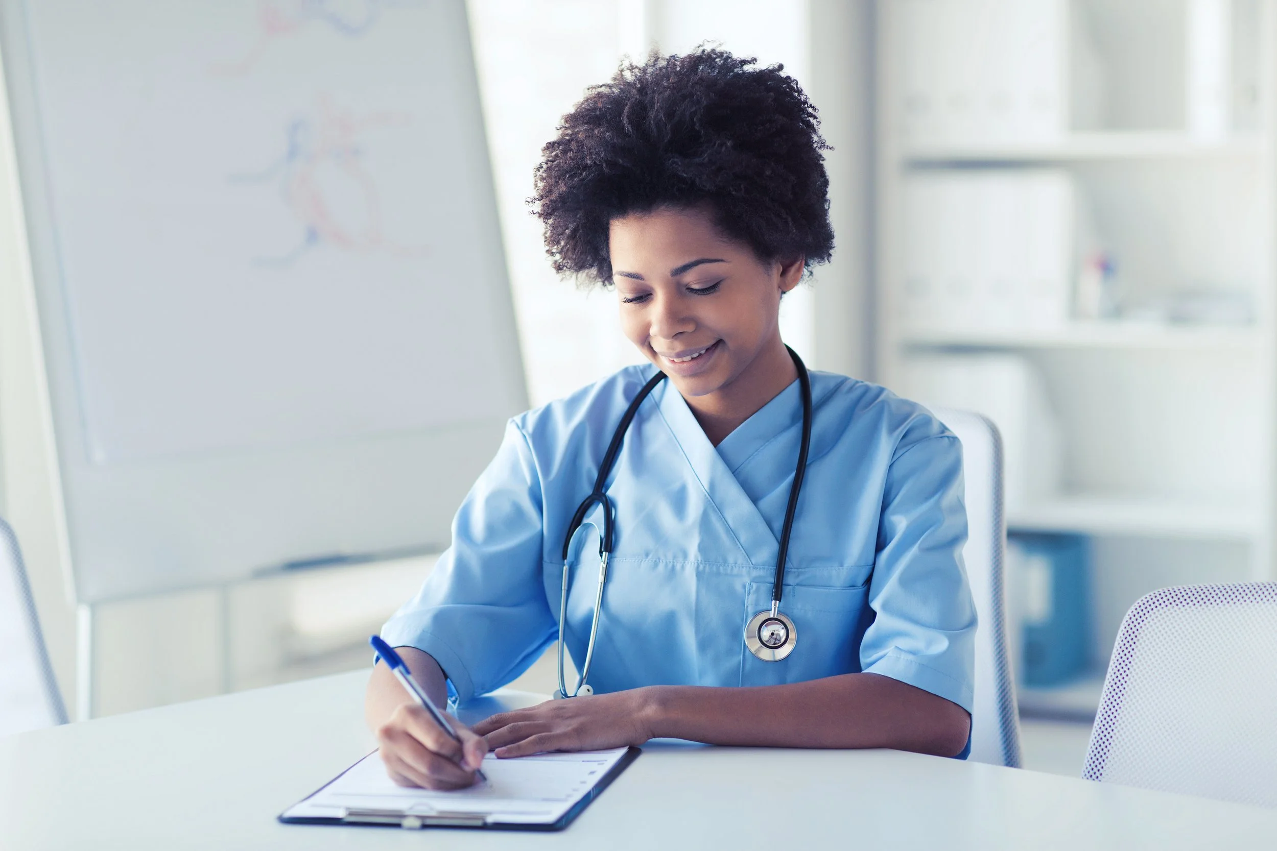 happy-female-doctor-or-nurse-writing-to-clipboard-2021-08-26-22-50-56-utc.jpg