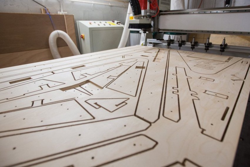 sheet of plywood components being cut using cnc