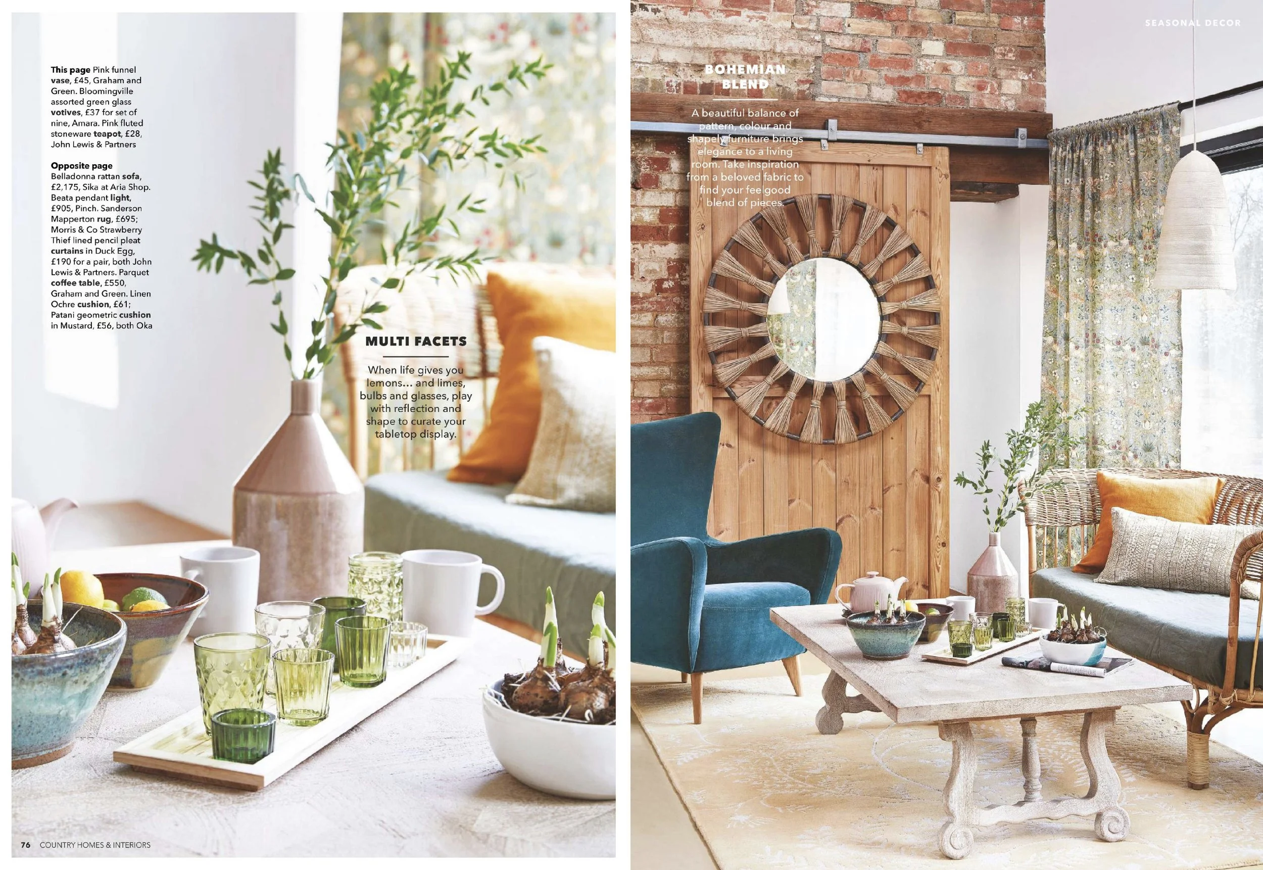 Living room with a brick wall and exposed wooden beam, decorated with a large circular mirror with a woven frame, teal armchair, and rattan sofa with pillows. A wooden coffee table holds a teapot, cups, and decor. There are floral curtains and a whit