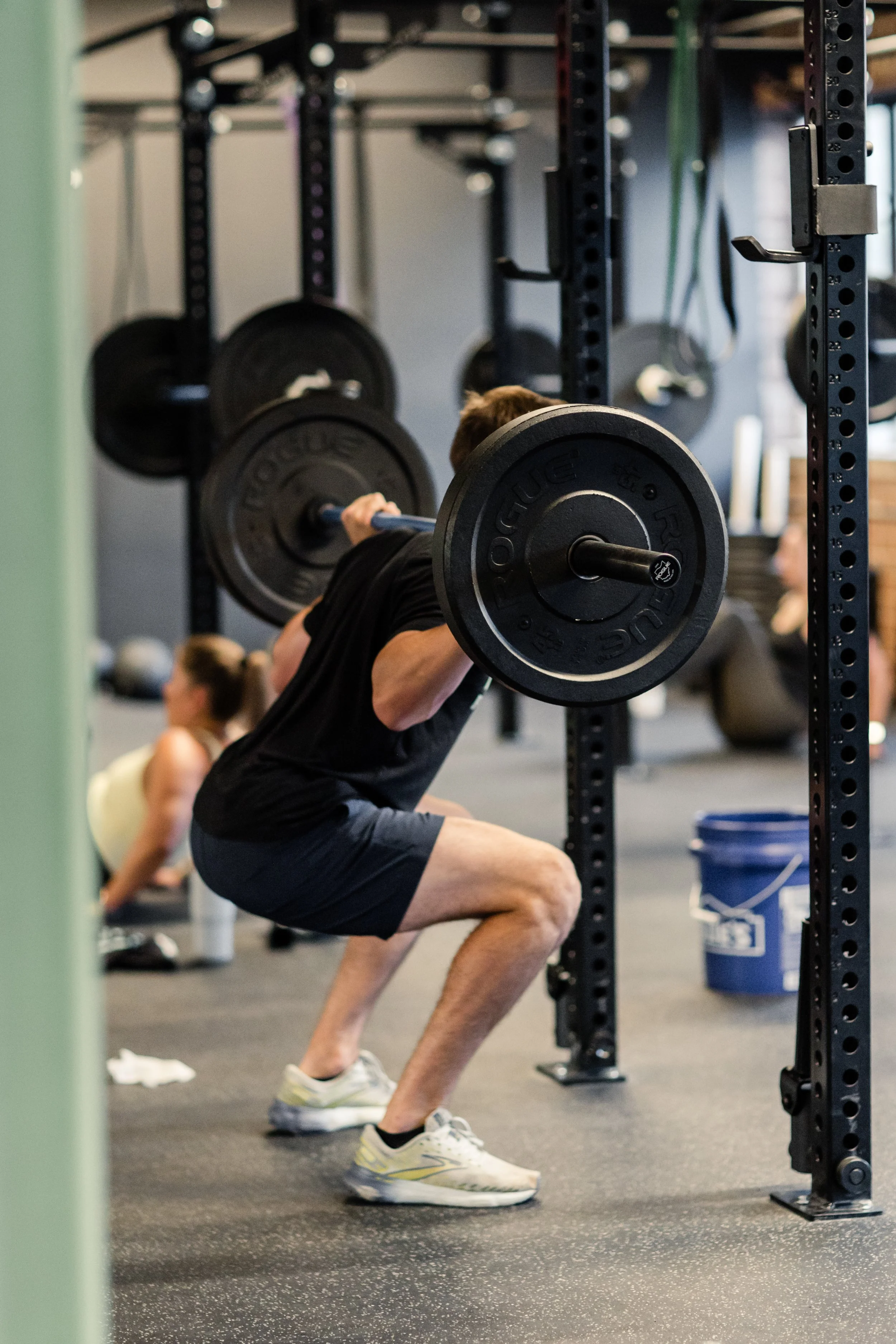 Member doing a barbell back squat during a strength class at Fuel Bootcamp in Charlotte