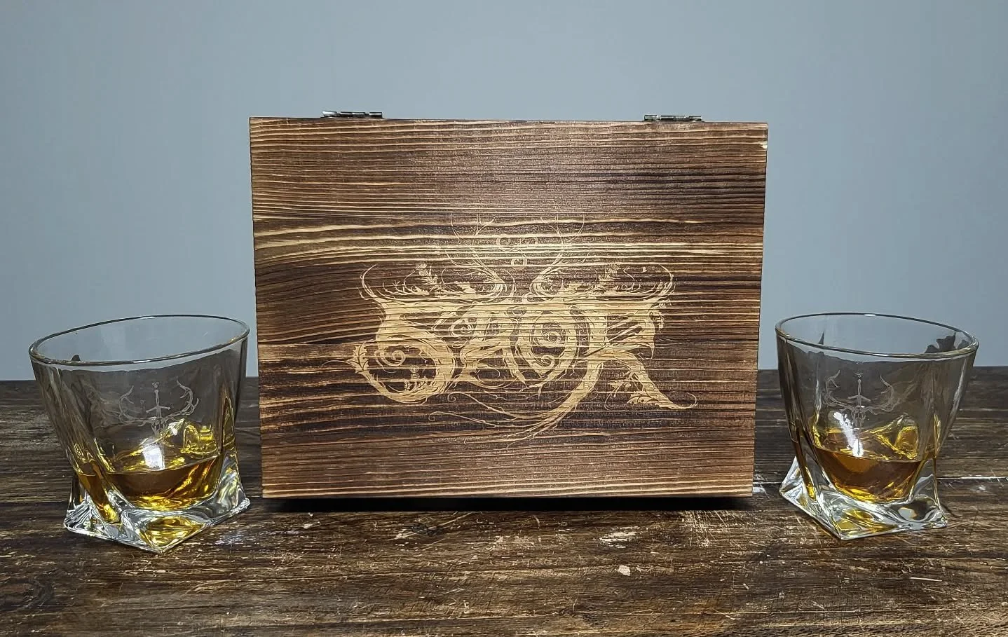 Clan! Our handmade Wooden Whisky Box is the perfect companion for your Caledonian metal sessions - crafted from untreated rosewood, featuring two engraved whisky glasses and six marble cooling stones with the iconic sword/stag sigil. A proper way to 