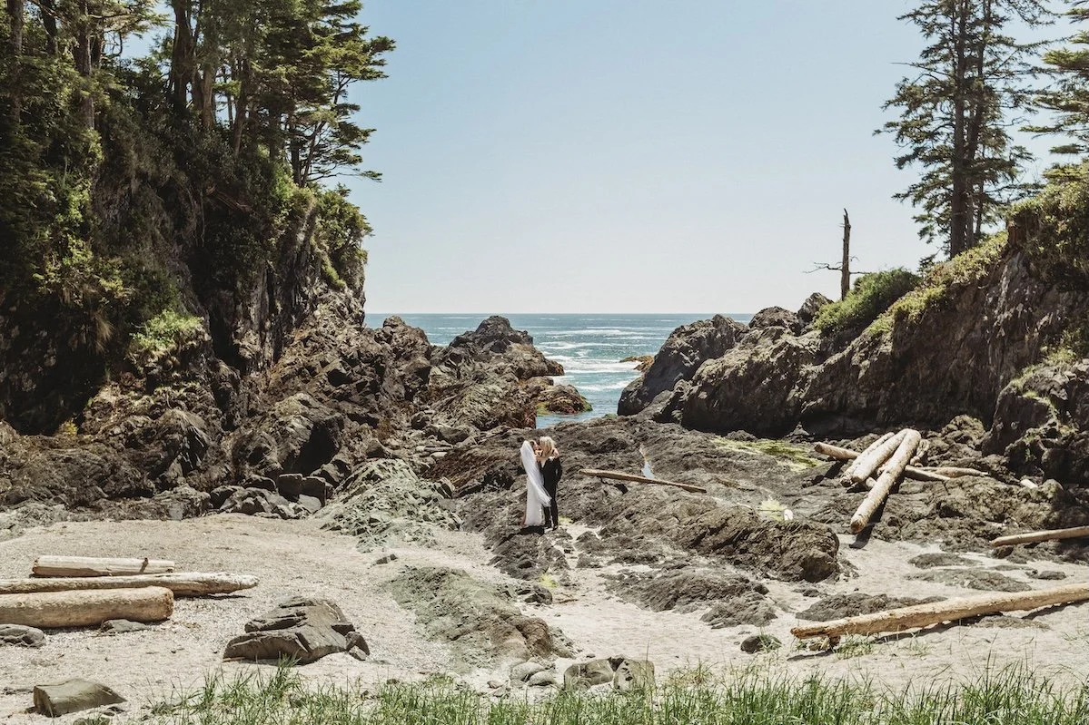 Bride and groom embracing on a rocky shoreline in Ucluelet