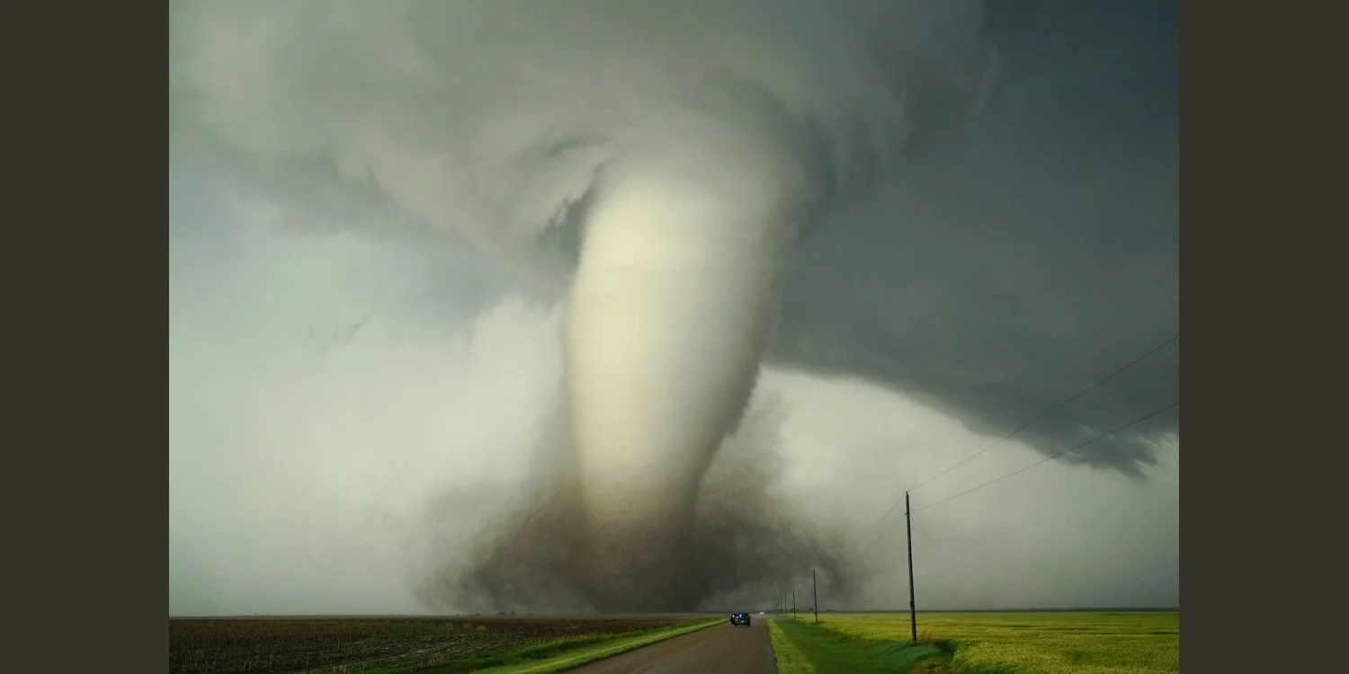 Unsplash photo by Greg Johnson shows a large tornado coming down on a road.