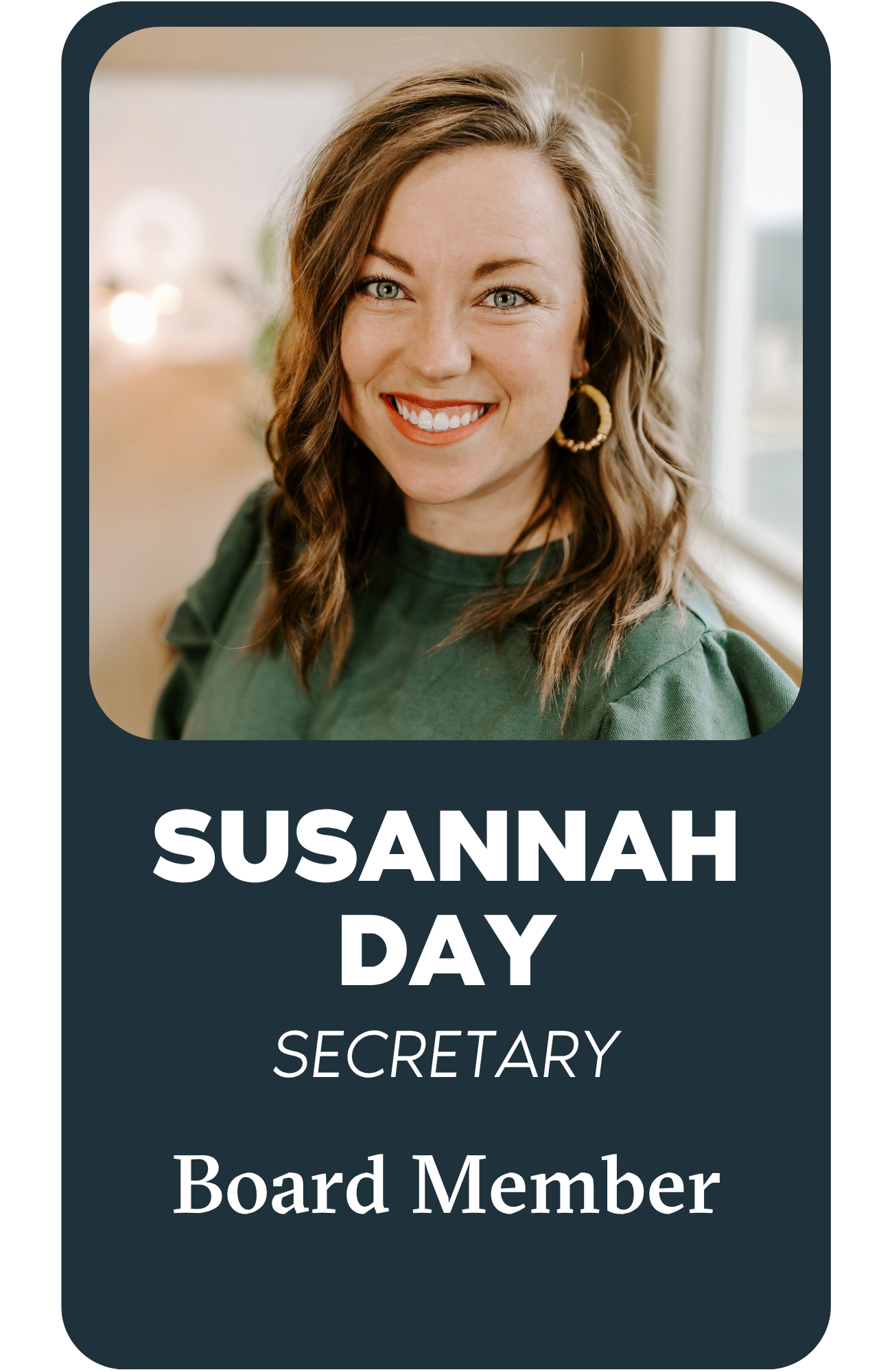 Name tag with a compass symbol at the top, text reading 'Susannah Day' in bold and 'Board Member' below.