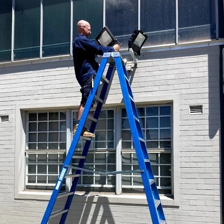 electrician-repairing-floodlights-in-common-area-newcastle.jpeg
