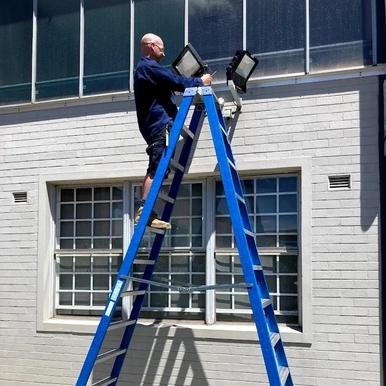 electrician-repairing-floodlights-in-common-area-newcastle.jpeg