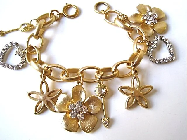 Pretty and feminine charm bracelet with gold flowers and rhinestone hearts for Sweet 16