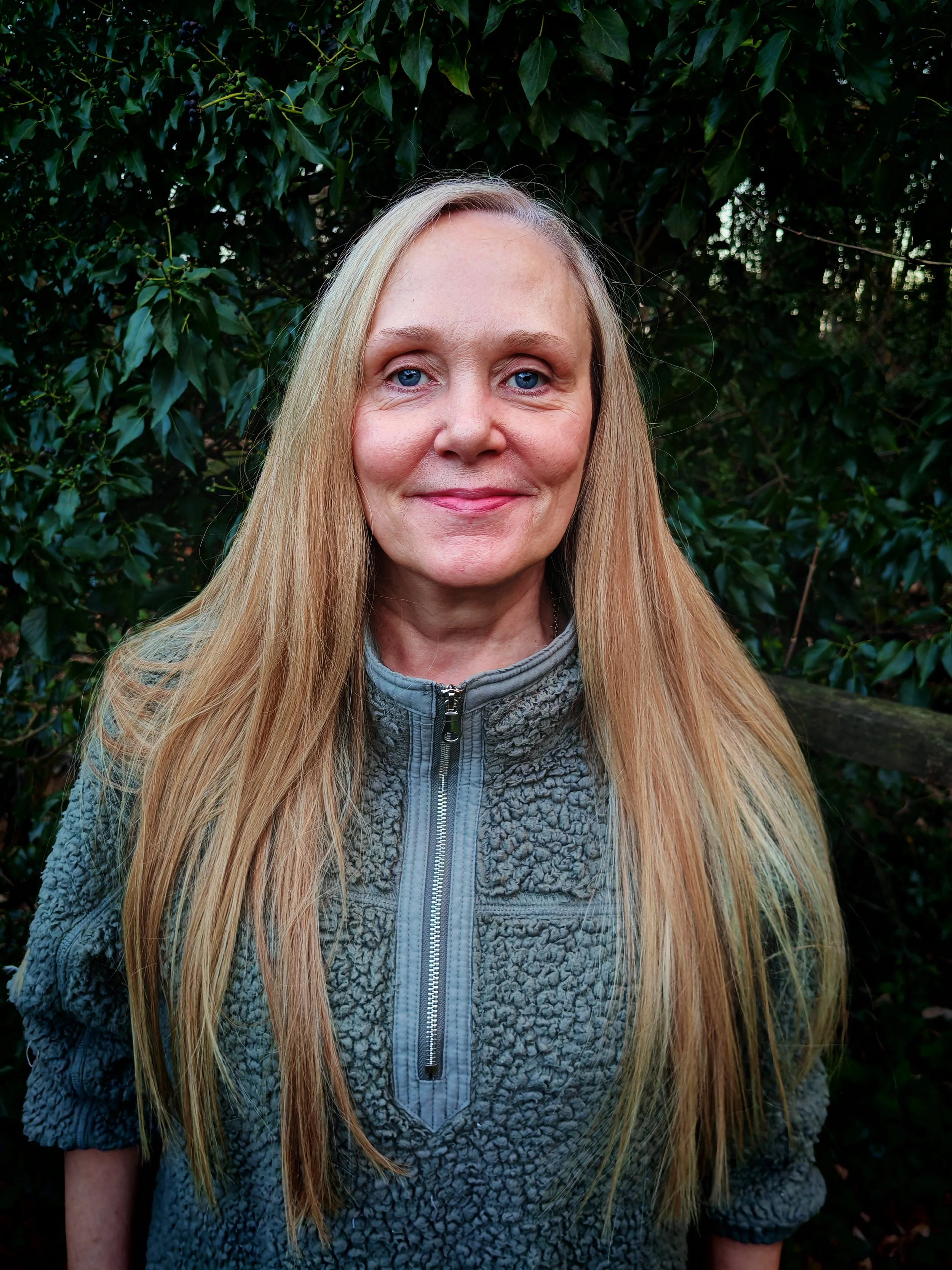Headshot of actor Pamela Bateman-Lee. Pamela has long brown hair and blue eyes. She is wearing a blue jumper with a zip in the middle