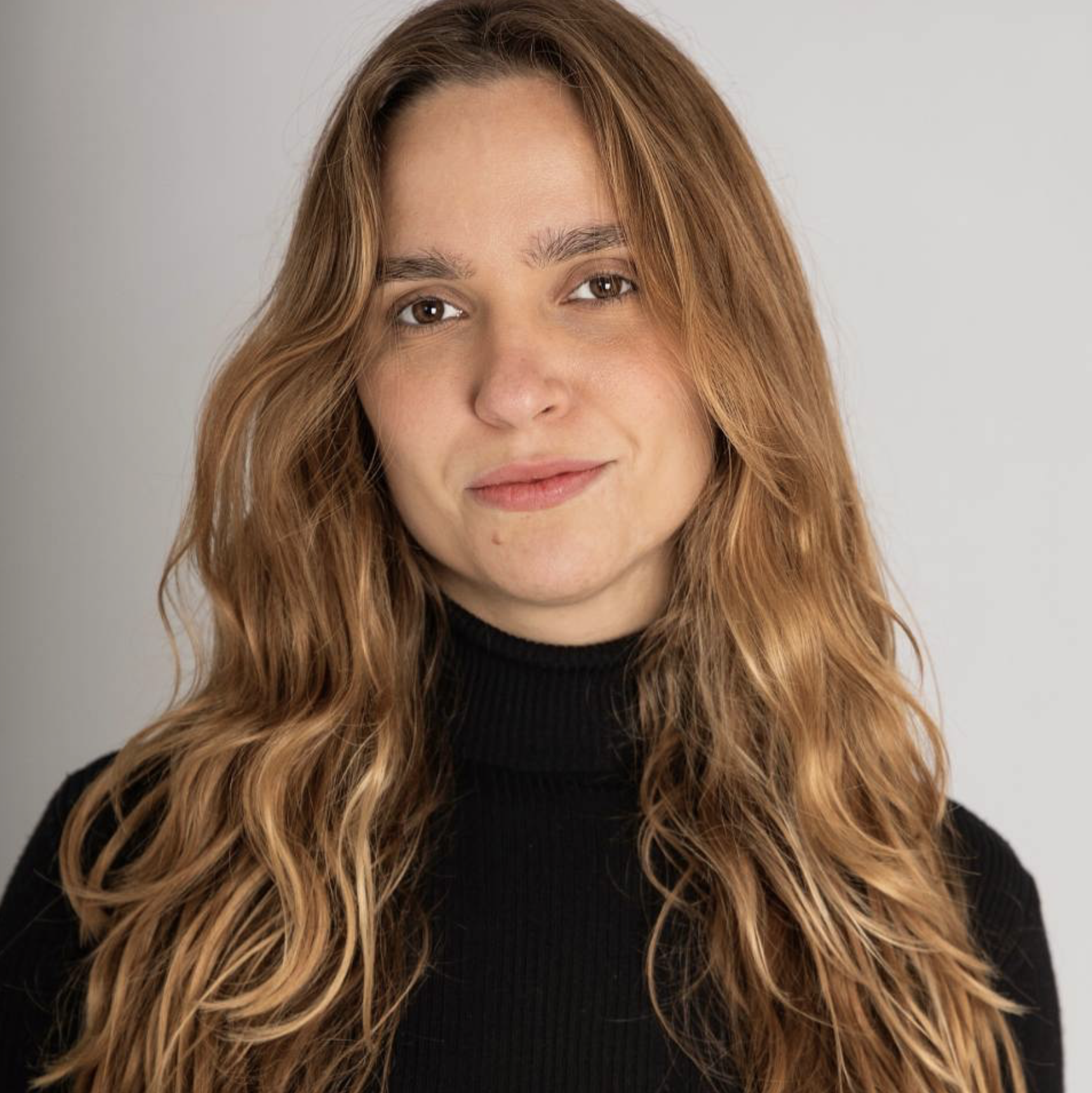 Headshot of actor Jasmin Cortez. Jasmin is a non-binary (female presenting) young adult with dark blonde, long, wavy hair.  They have light vitiligo on their neck