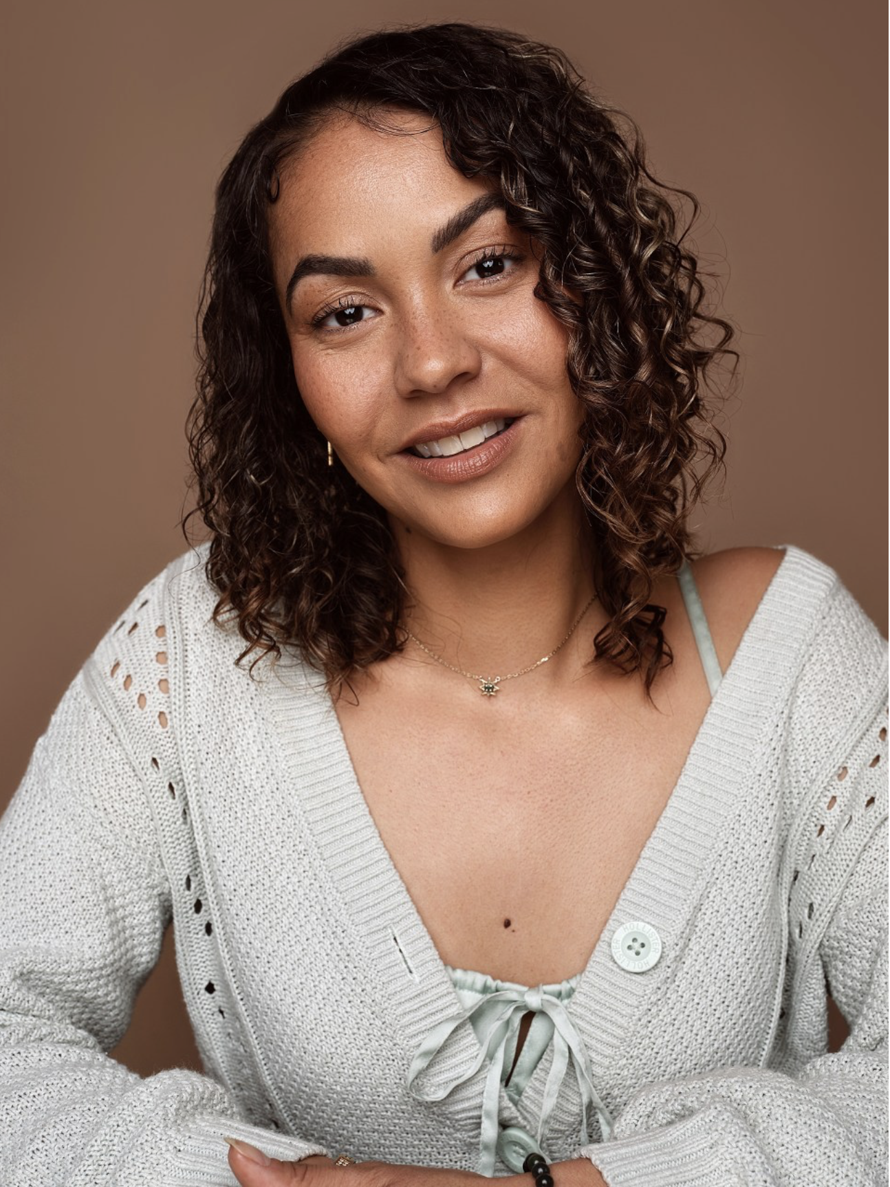 Headshot of actor Denny Rae. Denny is a mixed race female between the ages of 25-35. She has brown hair