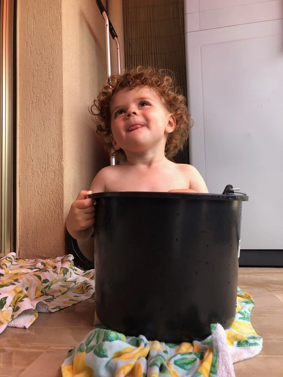 Boy in a bucket.  This kid loves small spaces.