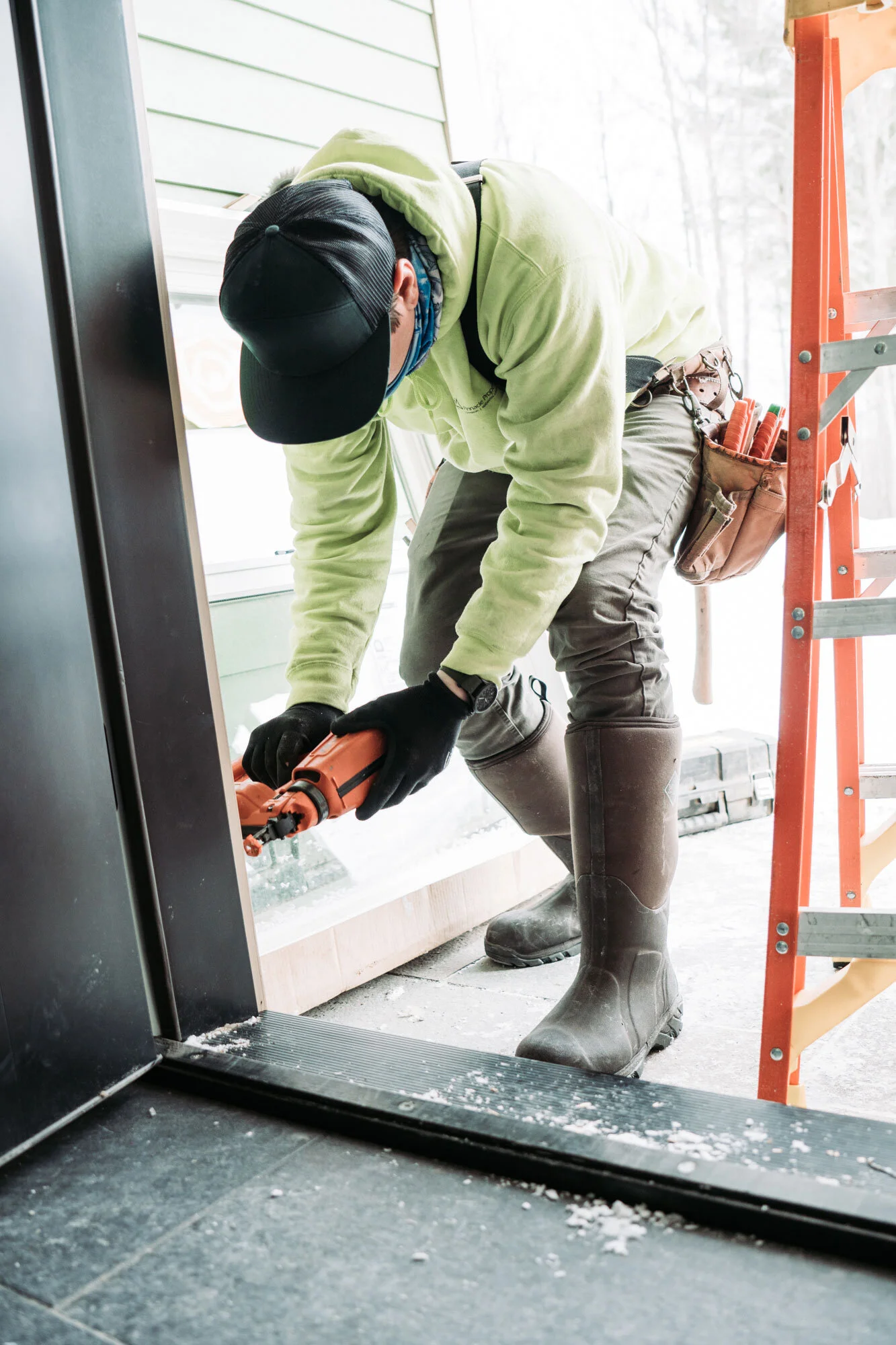 Construction worker using a caulking gun near a window