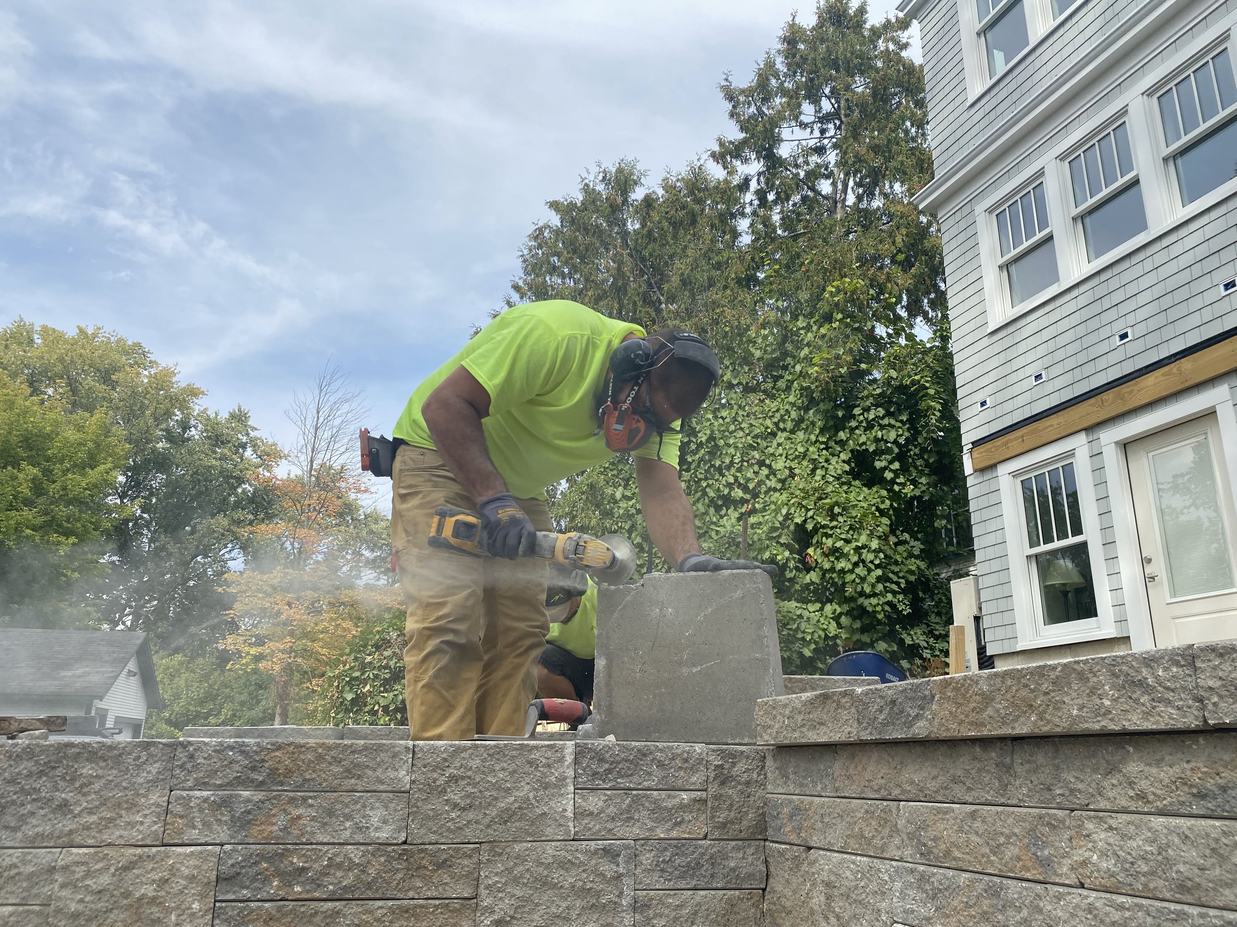 pinnacle properties landscaper working on a retaining wall in vermont