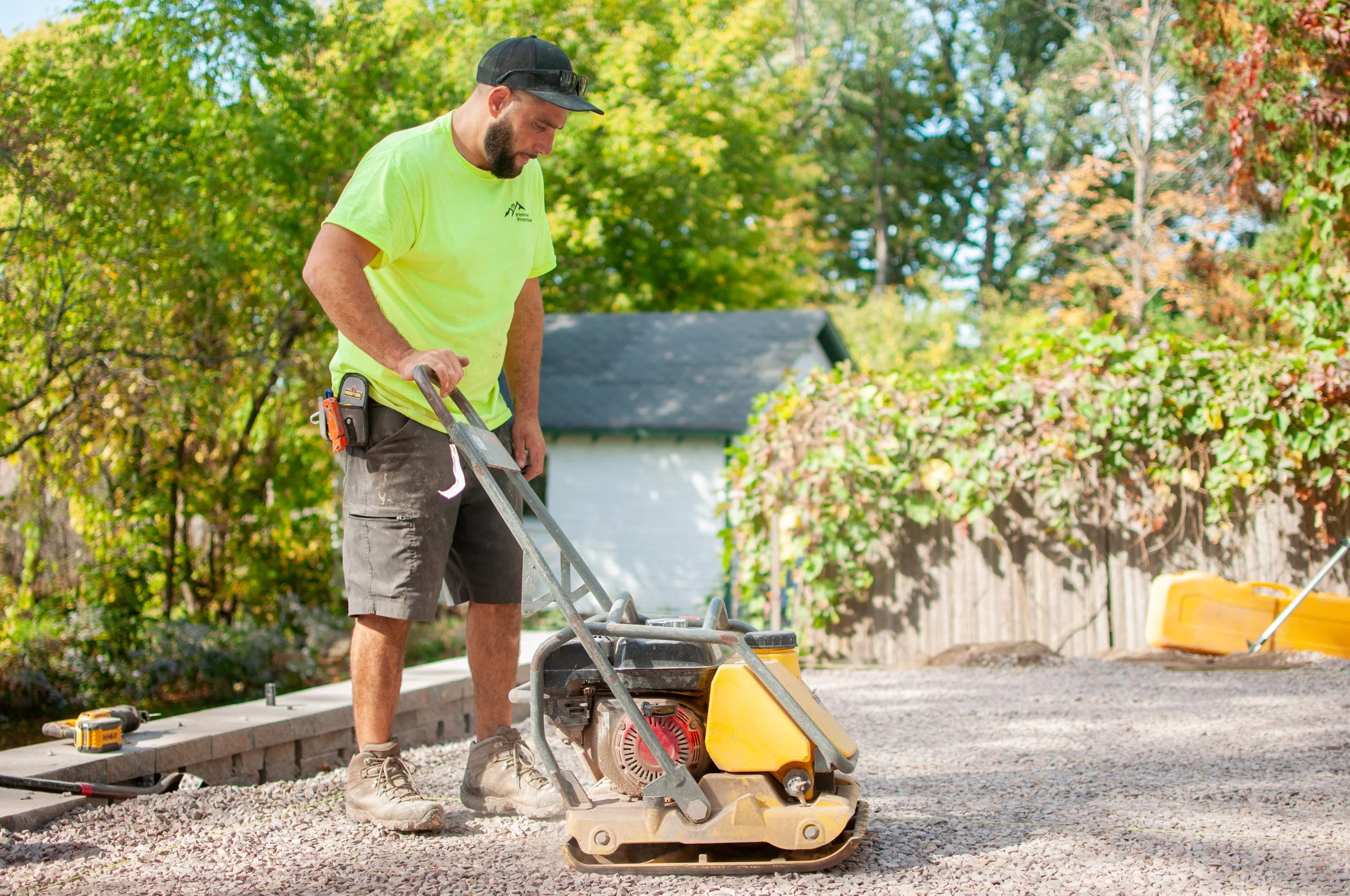 pinnacle properties crew member preparing gravel for a patio