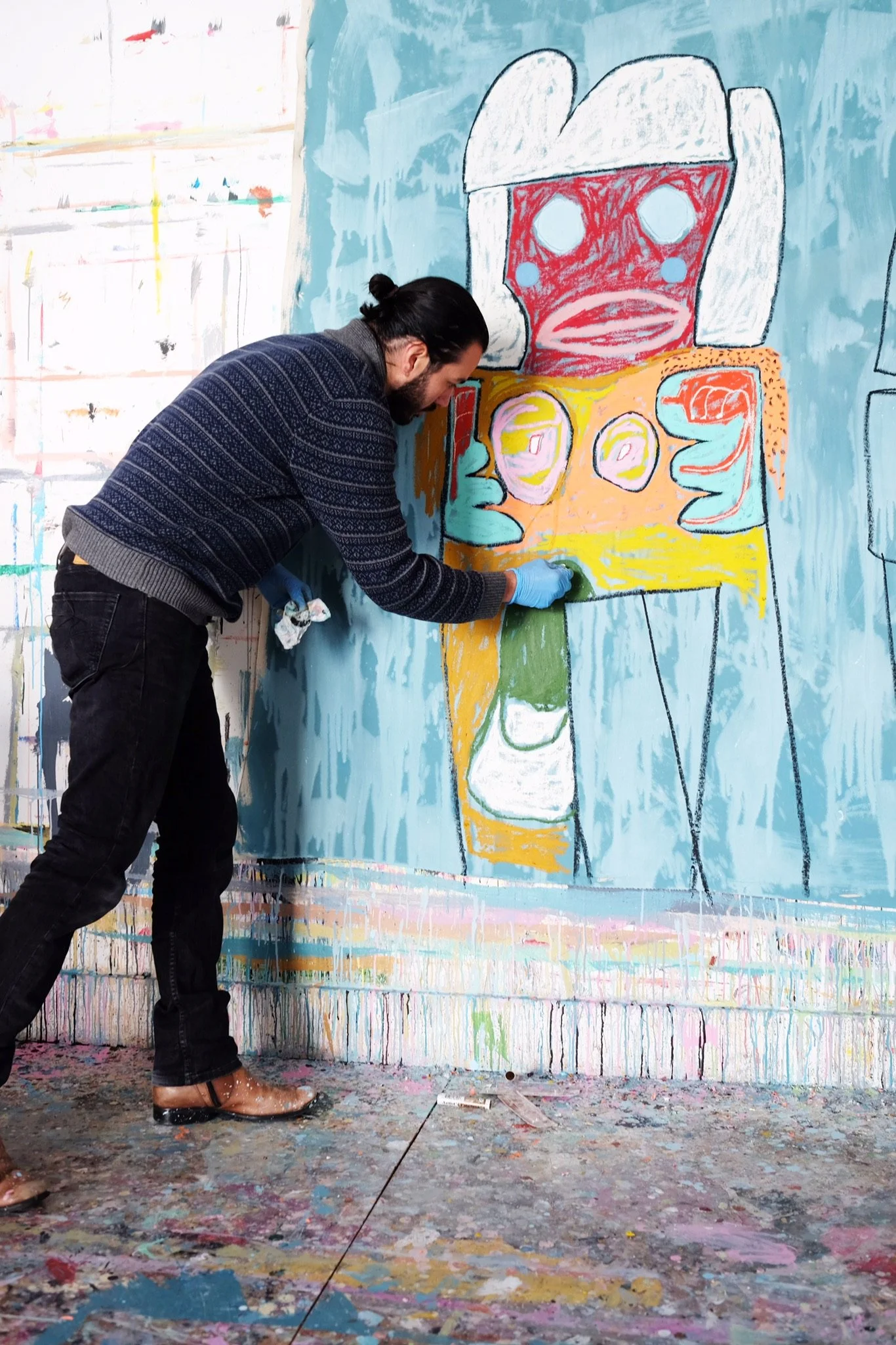 Adam handler  painting a mural on a wall - He paints a powerful human figure with robust lines