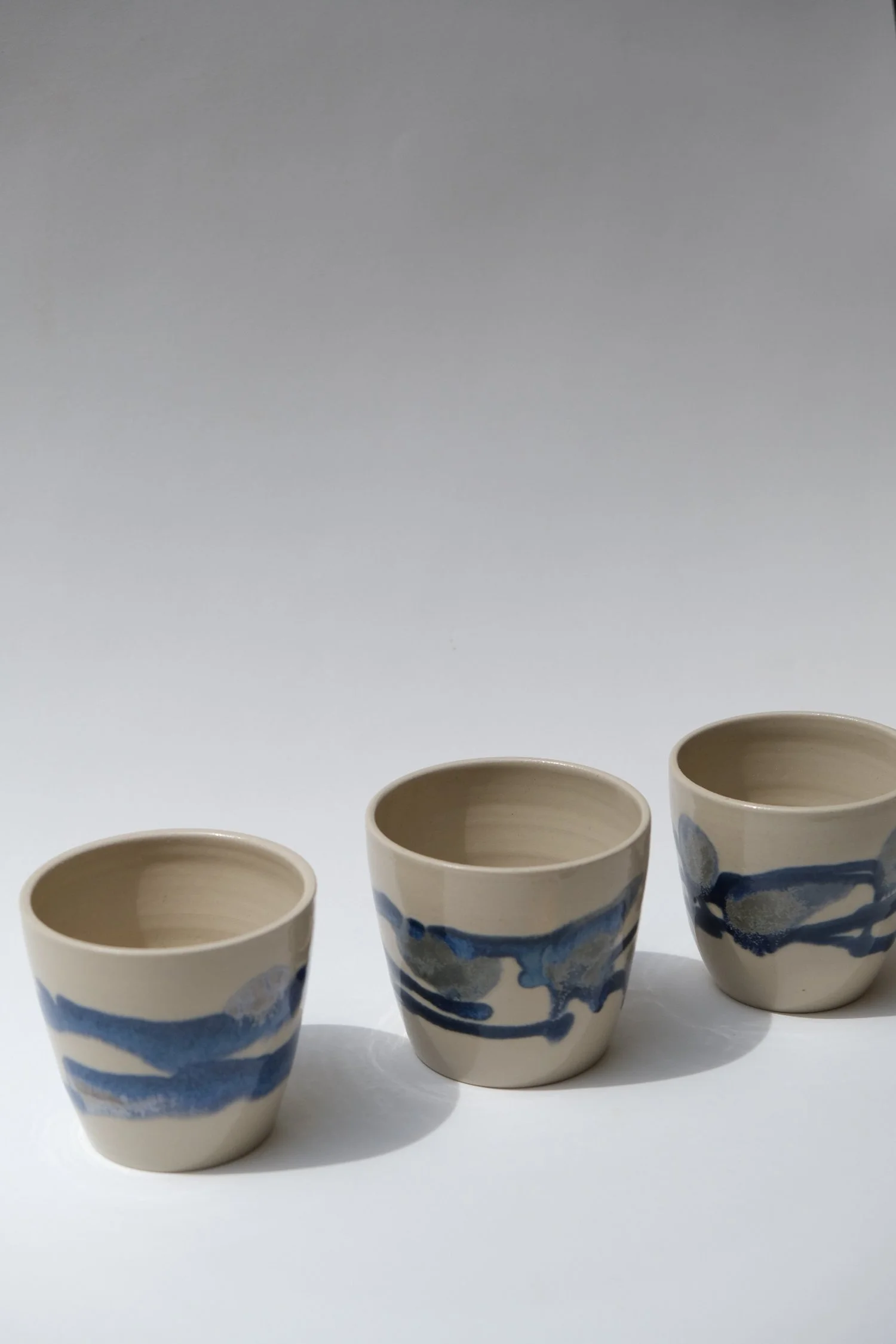 three cups with blue and transparent glaze