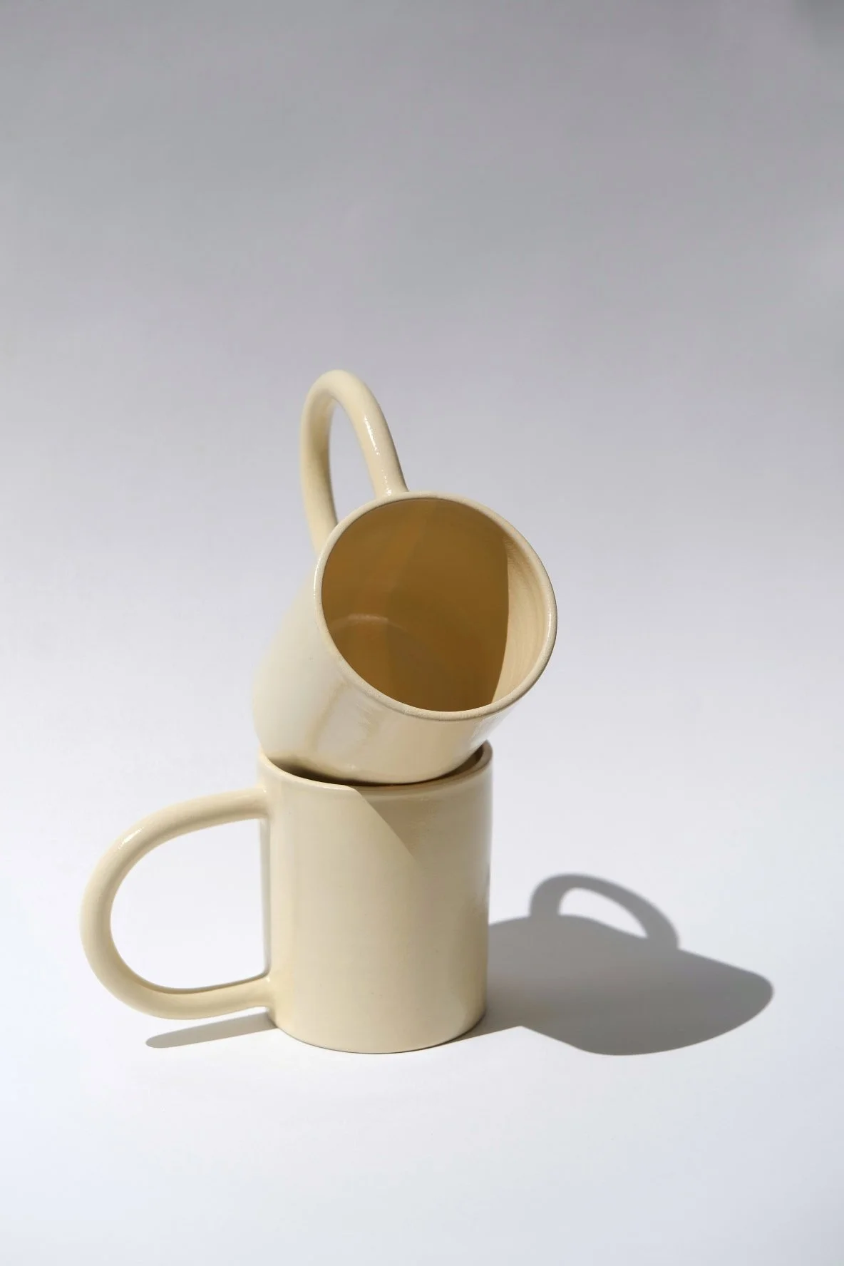 two ceramic mugs with handles in butter yellow
