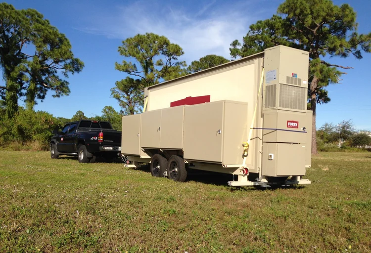 Folded FORTS 38 shelter carried on a Mobilizer trailer behind a pickup truck