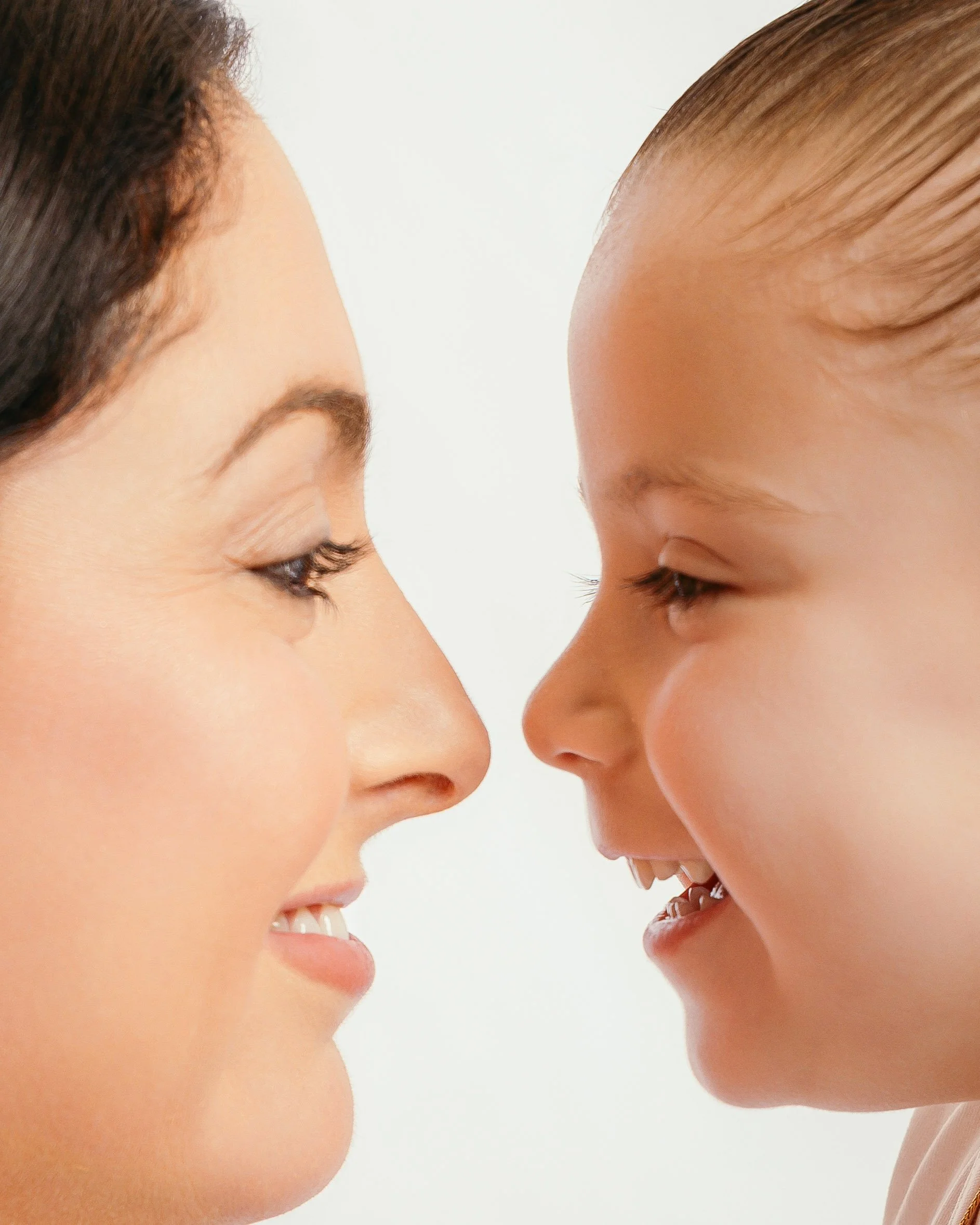 Close-up portrait of a mother and child sharing a joyful moment during a family portrait session.