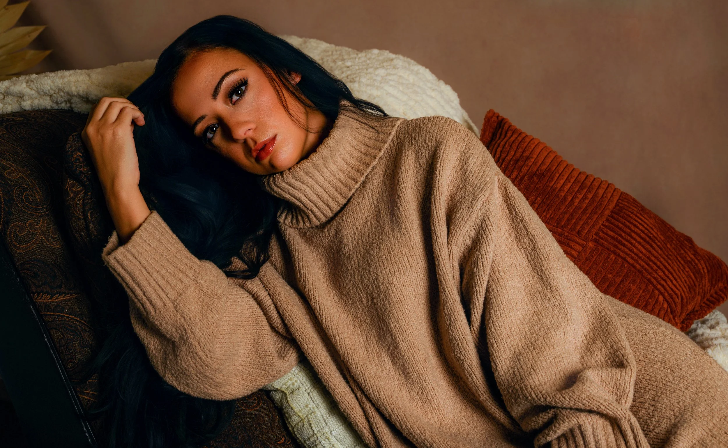 Intimate boho boudoir portrait of a woman in an oversized beige sweater, photographed with warm, soft lighting by Michael Rocco Photography in Woodbury Heights, South Jersey.