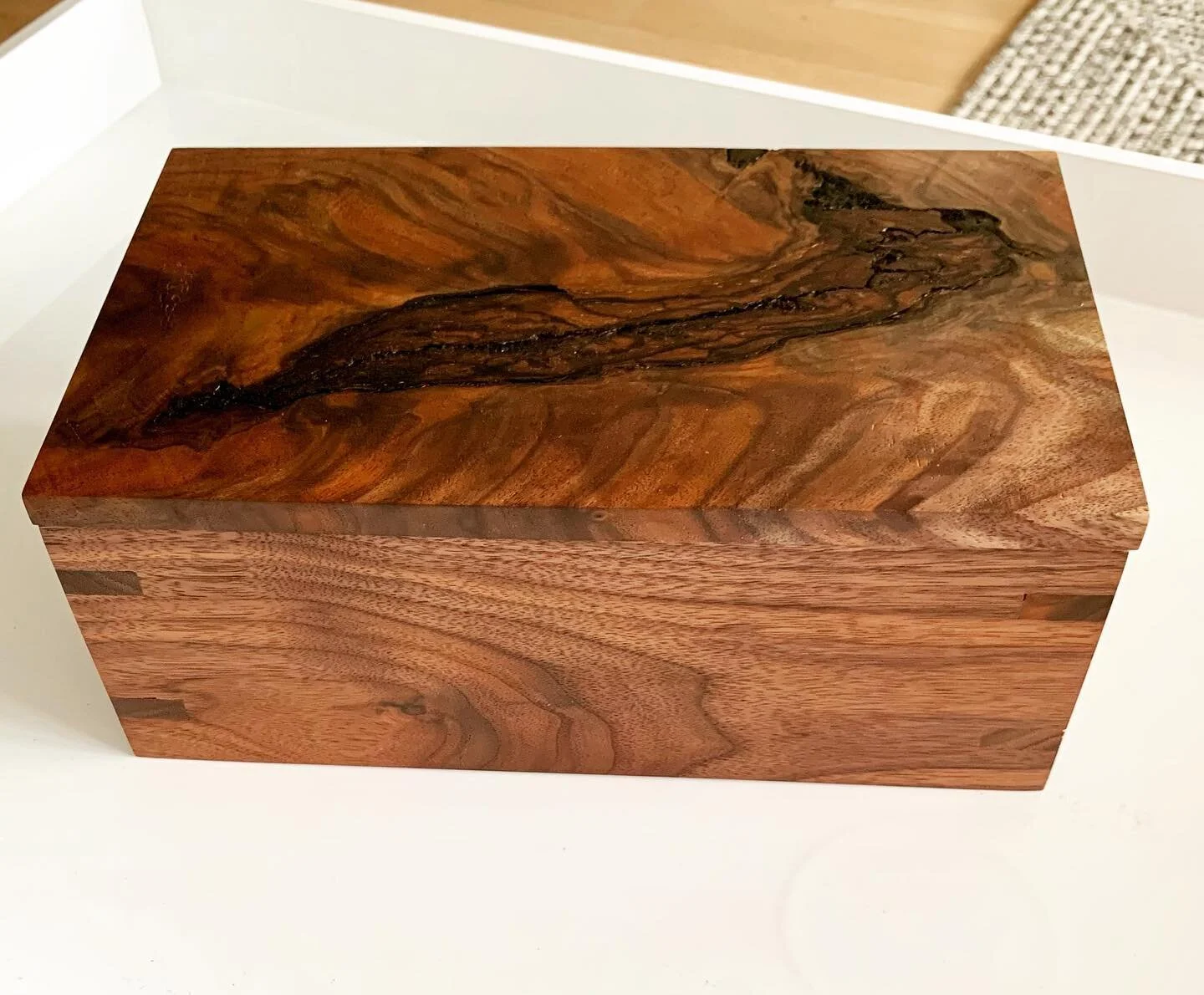▪️A box with a variety of purposes

Made with rich walnut from a family friend&rsquo;s property, this project was a family effort. 

Featuring slotted box joints &amp; a highly figured live edge top.  Our goal was to highlight and enhance the natural