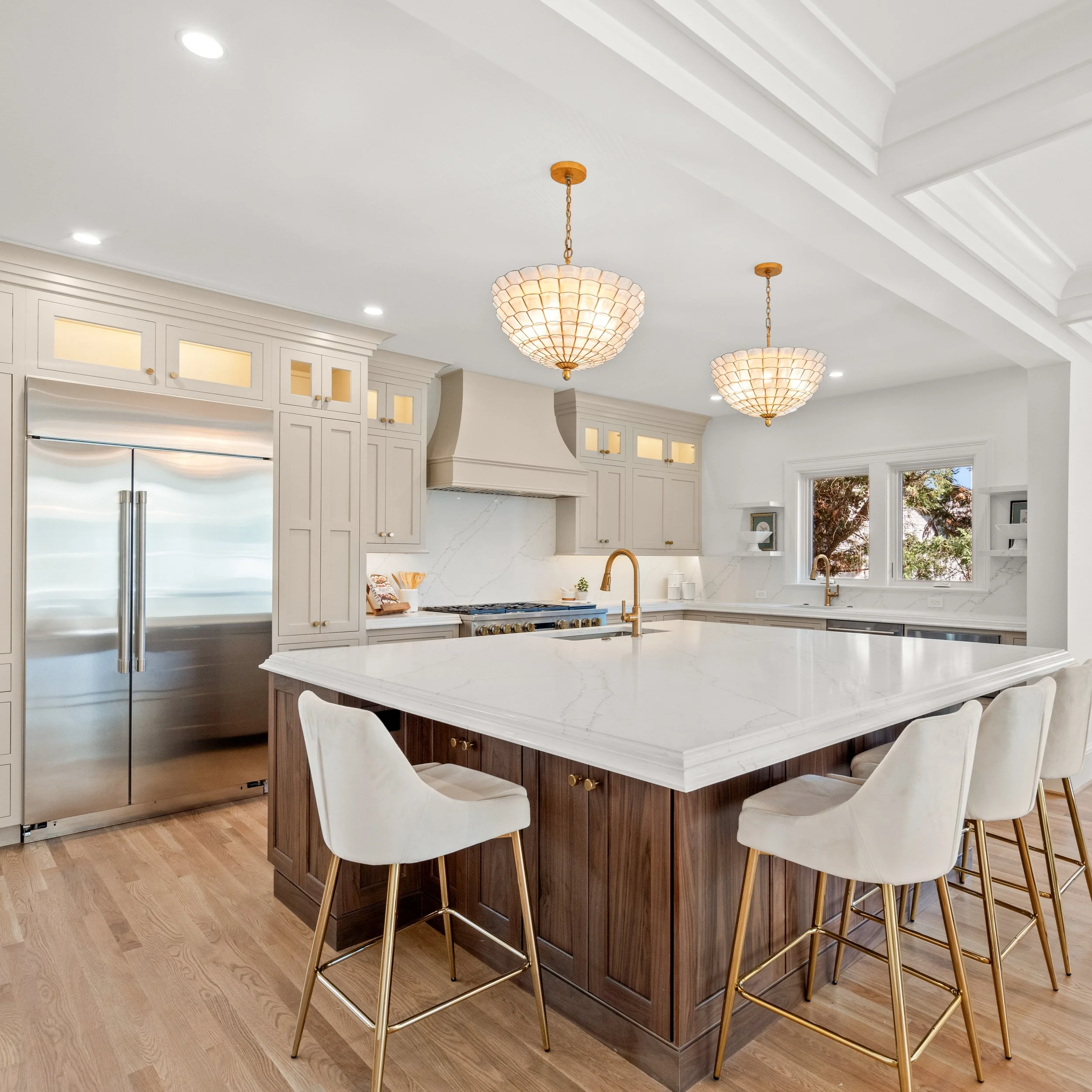 Creamy perimeter cabinetry meets a stunning natural wood island. The perfect recipe for a timeless heart of the home.