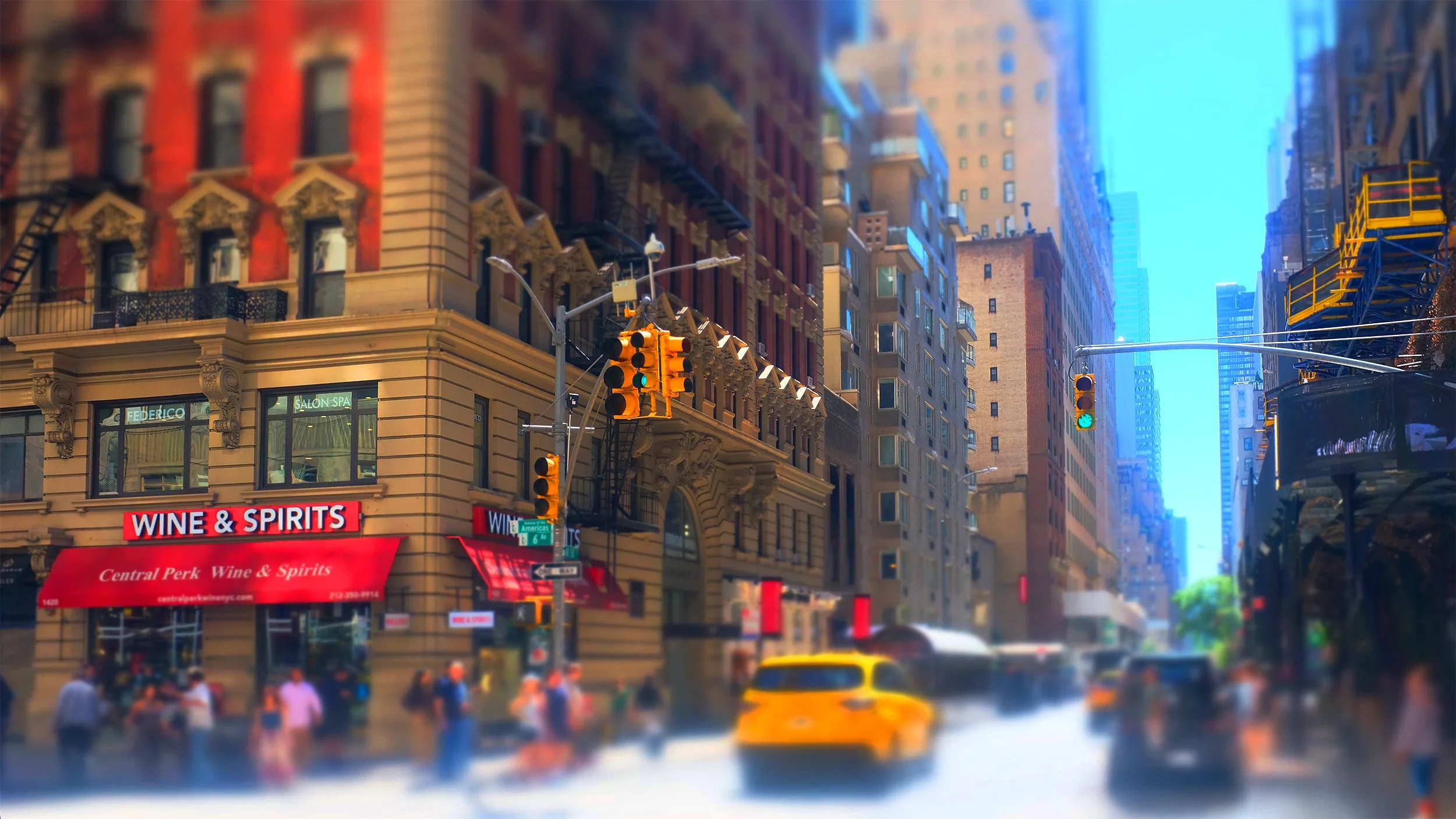 City street scene with tall buildings, traffic lights, a yellow taxi, and pedestrians. Store signs include 'Wine & Spirits' and 'Salon Spa'.