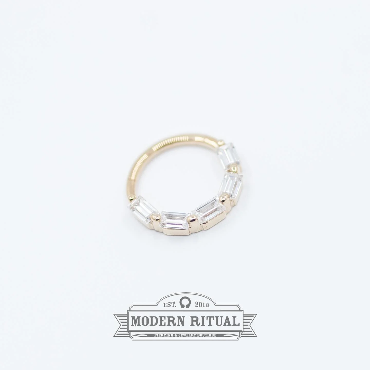 This 14k CZ Baguette Clicker from @sun_piercer_bodyjewelry is looking for the perfect septum or daith to call home! Dave and Lea are in the shop till 7pm tonight so stop in soon!

#sunpiercer #gold #cz #baguette #clicker #daithjewelry #septumjewelry 