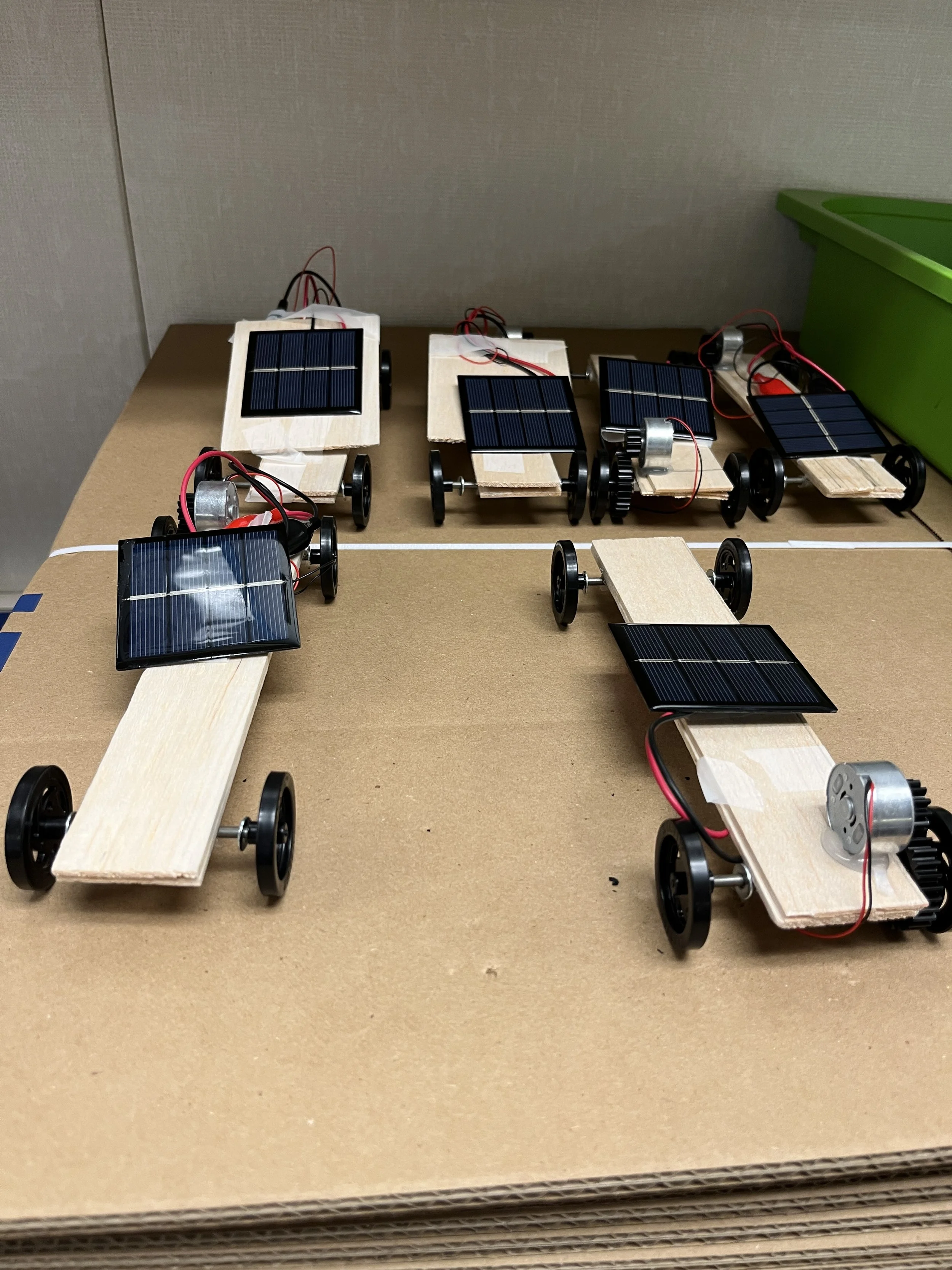 The "Solar Cars" lesson teaches about renewable resources by building small solar-poowered cars, like the ones pictured here.