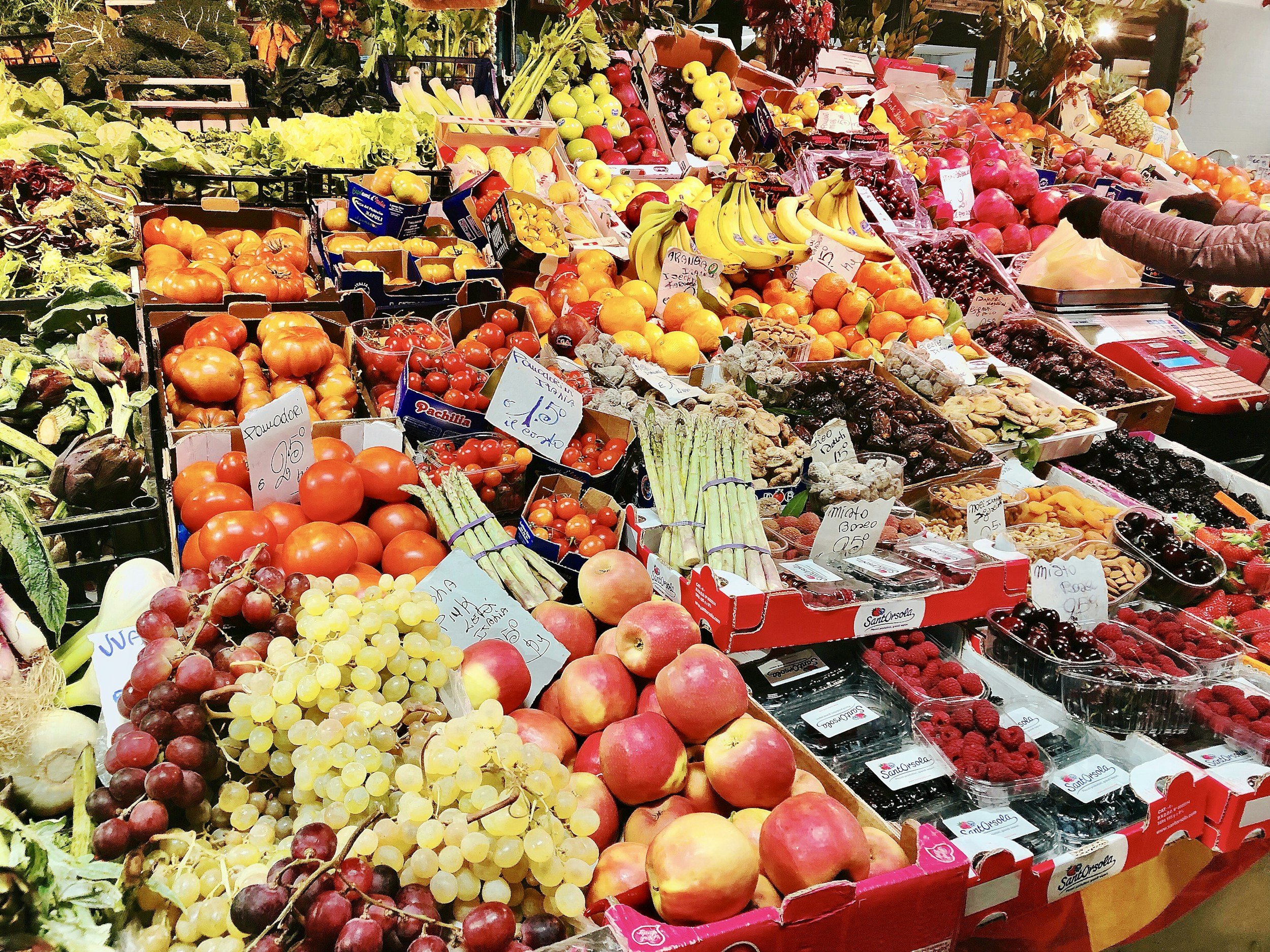 image of a produce stand with apples, berries, bananas, and grapes