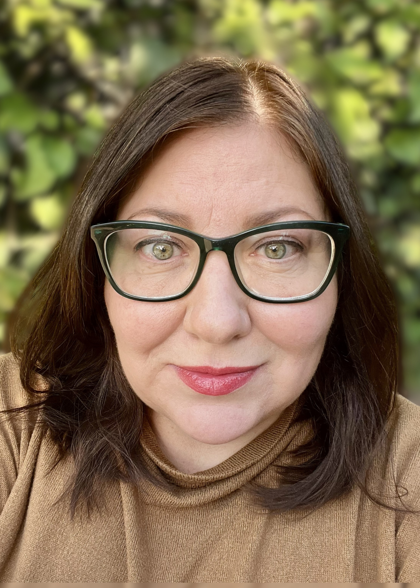 Photo of Summer smiling with her dark hair down and a brown top
