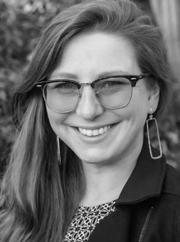 headshot of Suz wearing glasses with blonde long hair
