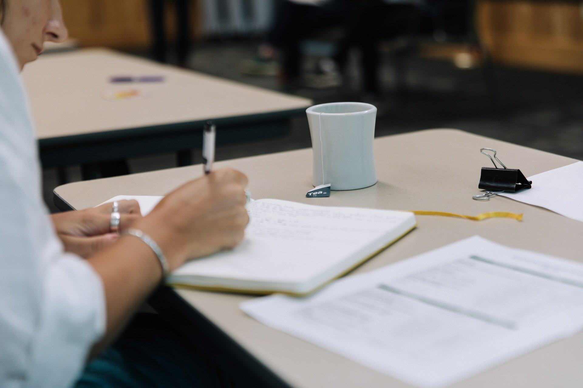 Person sitting at desk writing in notebook