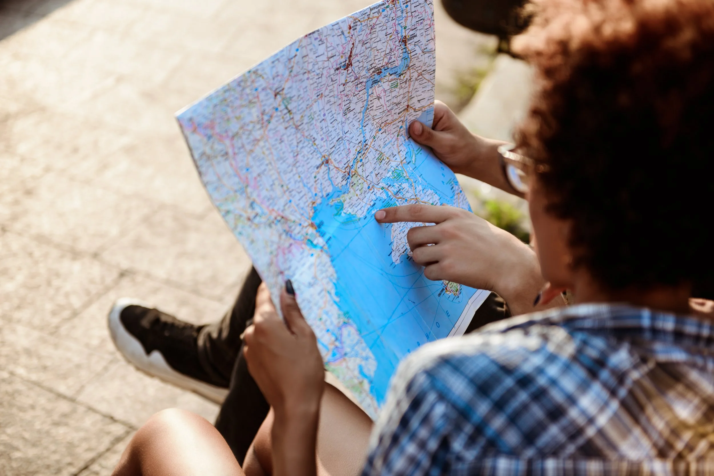 travelers-watching-route-map-sitting-bench-park.jpg