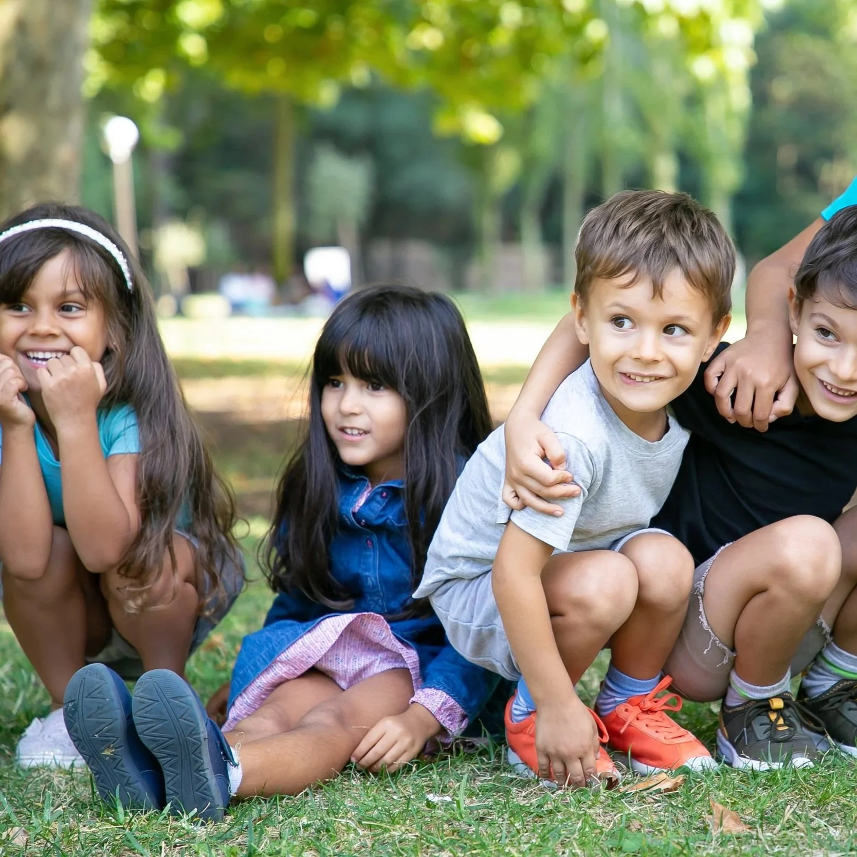cheerful-kids-sitting-squatting-down-grass-hugging-each-other-looking-away-excitement-kids-play-entertainment-concept.jpg