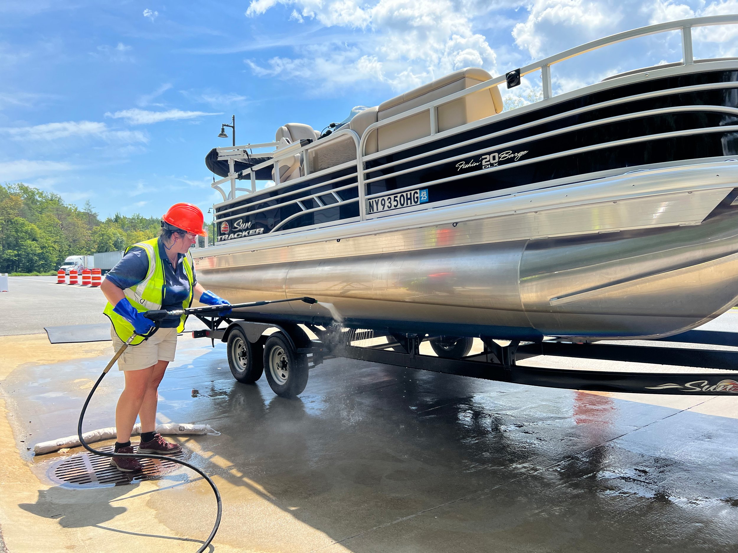  A Watercraft Inspect Stewards washes a pontoon boat. 