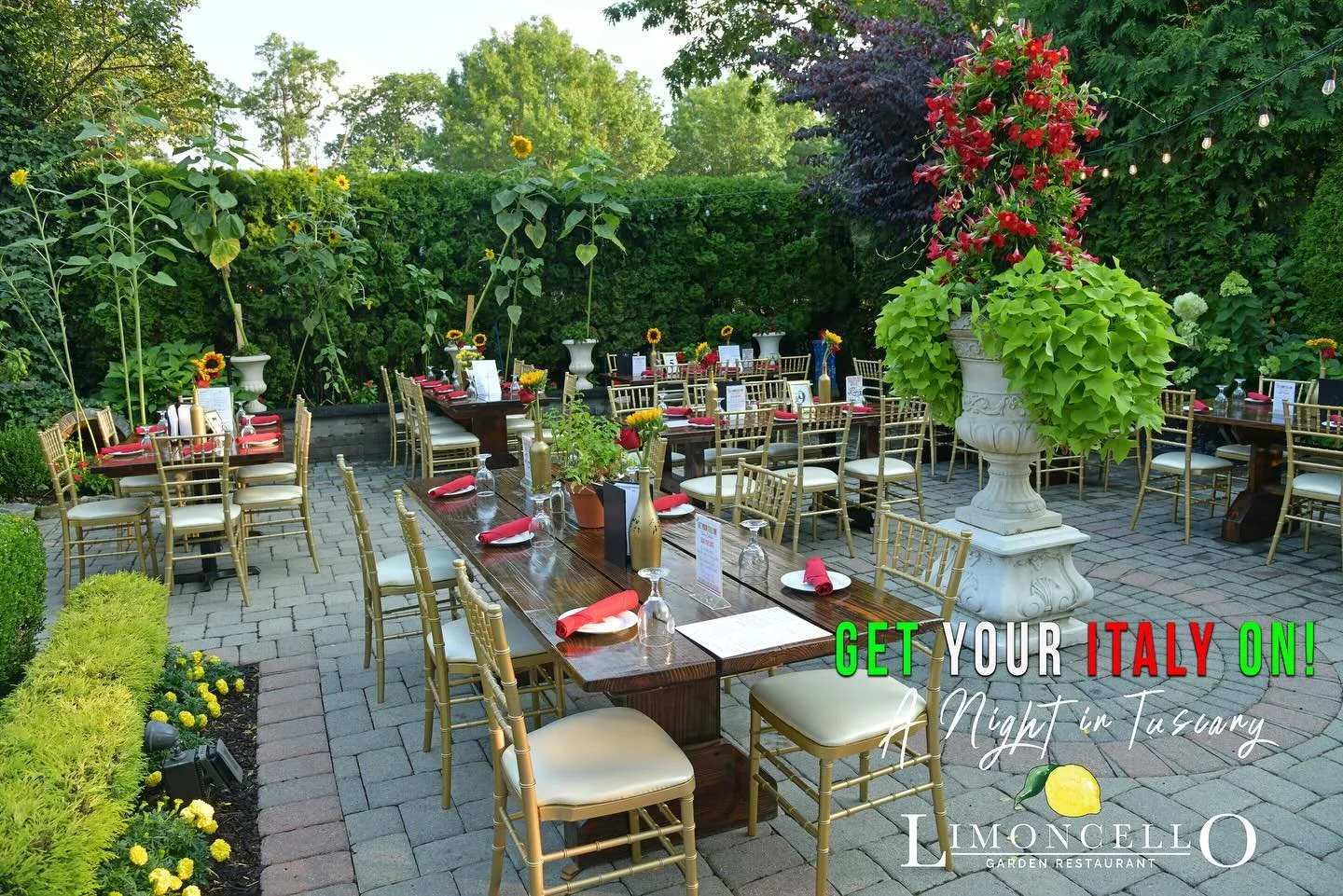 Outdoor dining area at Limoncello Garden Restaurant in Tuscany, Italy with decorated tables, gold chairs, large floral arrangements, and greenery.