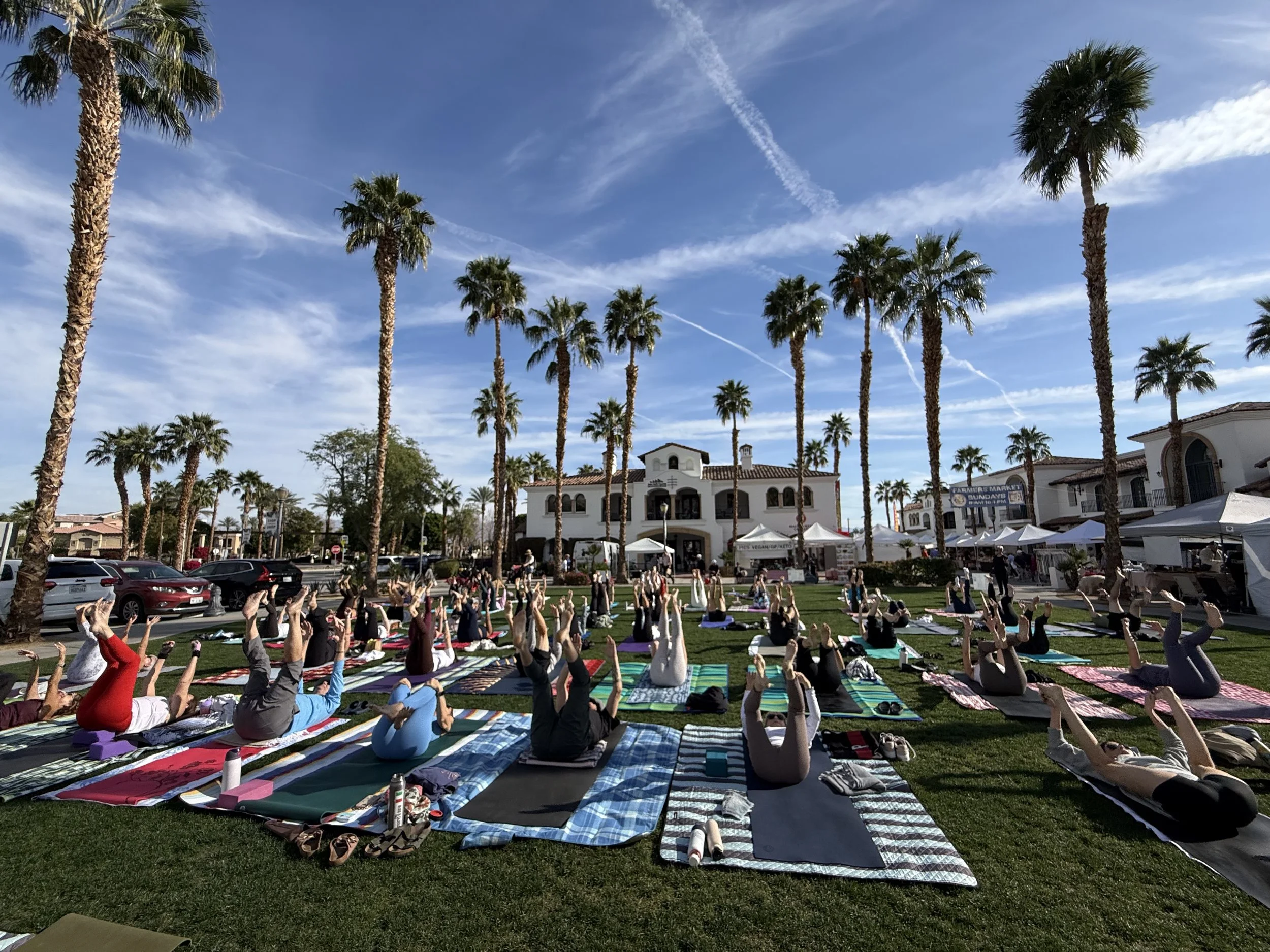 A person practicing yoga on a black mat, using two cork yoga blocks for support, one on each side, while kneeling on one knee with the other leg extended forward.