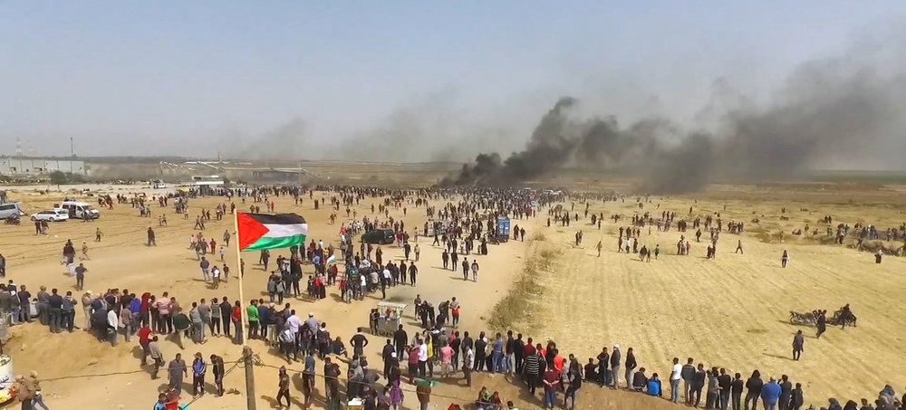  Drone photo of protesters walking towards the Gaza separation fence during the Great March of Return. (Image: UN News, https://news.un.org/en/story/2019/03/1035731) 