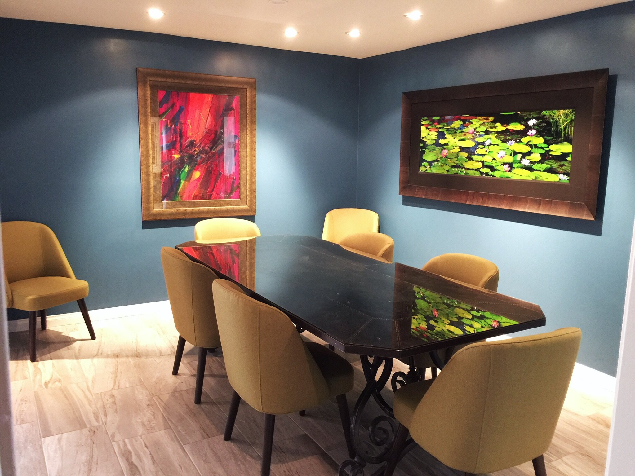 Modern eclectic dining room with navy walls, a dark wood table, and gold chairs by Gin Treadwell Interiors in Santa Clarita.