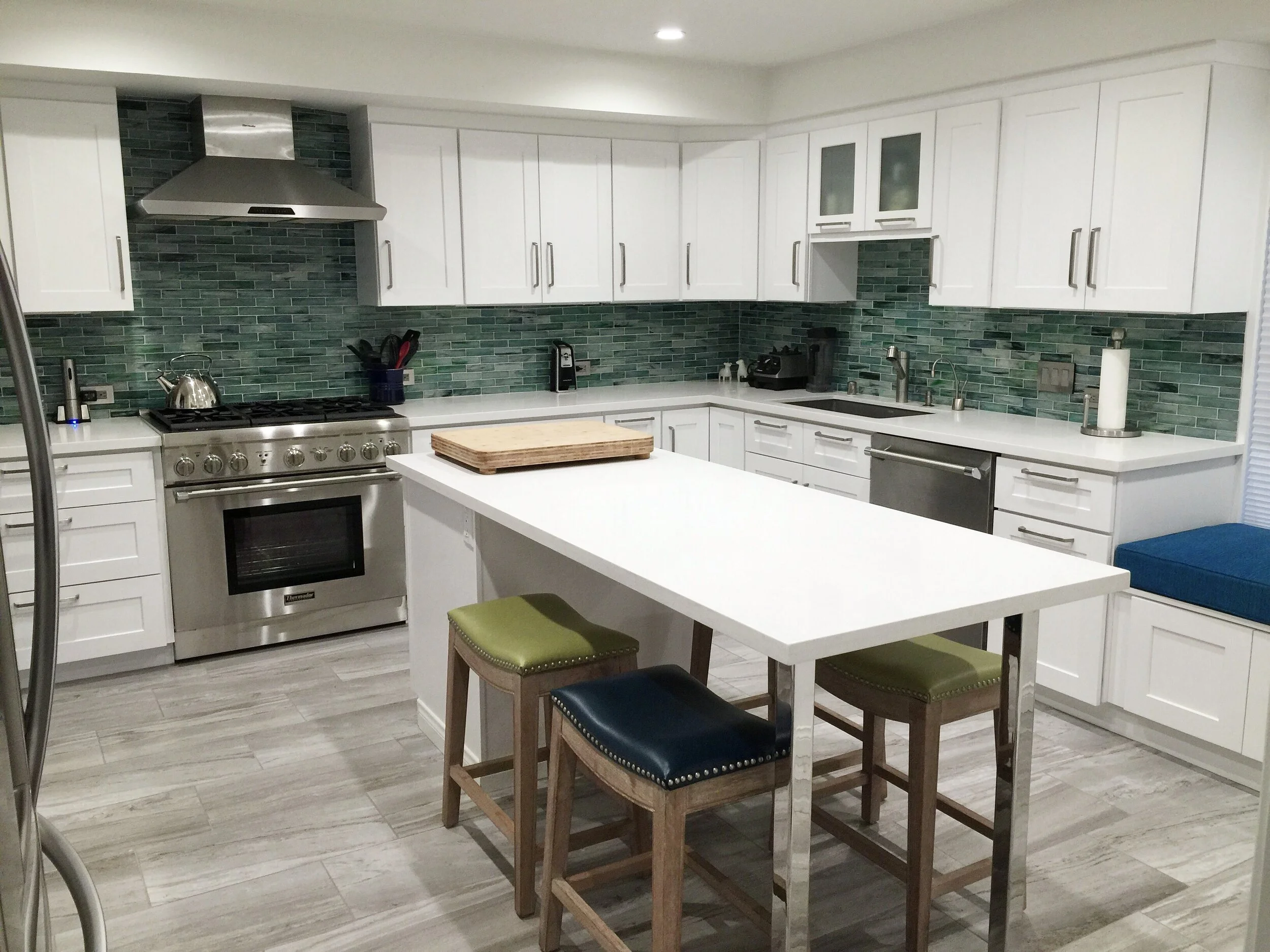 Modern eclectic kitchen with white cabinetry and a green tile backsplash by Gin Treadwell Interiors in Santa Clarita.